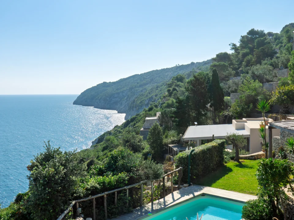 Stunning sea view with infinity pool and lounge area surrounded by greenery at Villa Alba.