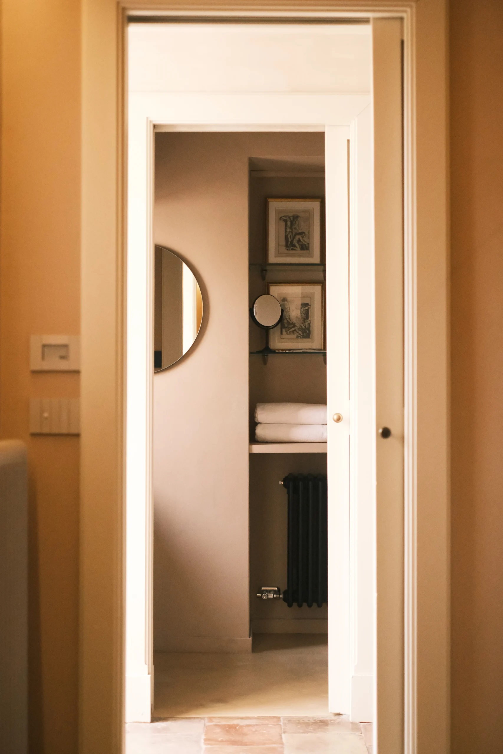 Bathroom entrance with stone doorway, natural plaster walls and minimalist Italian design