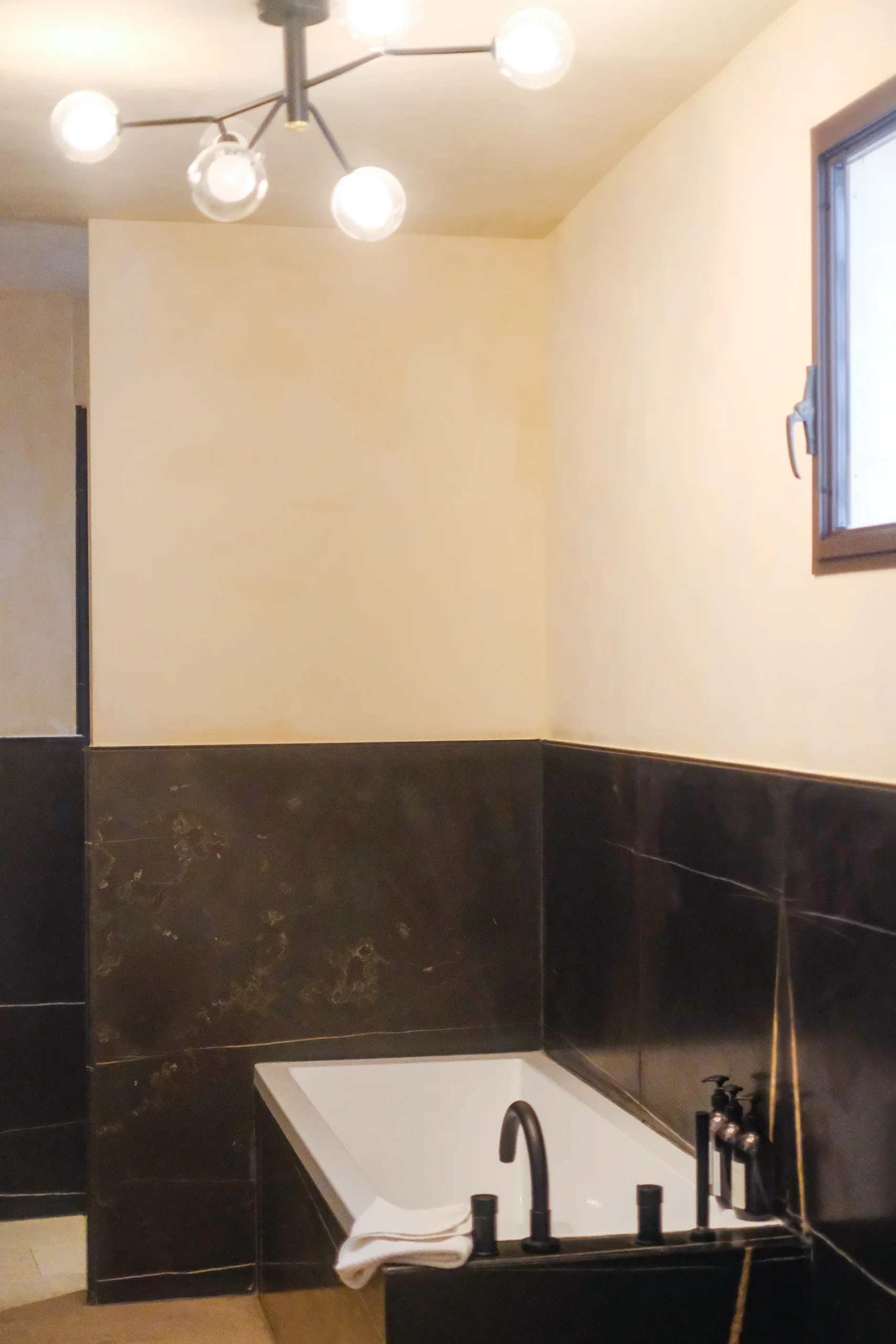 Detail of luxury bathroom with marble surfaces, bespoke fixtures and warm tones