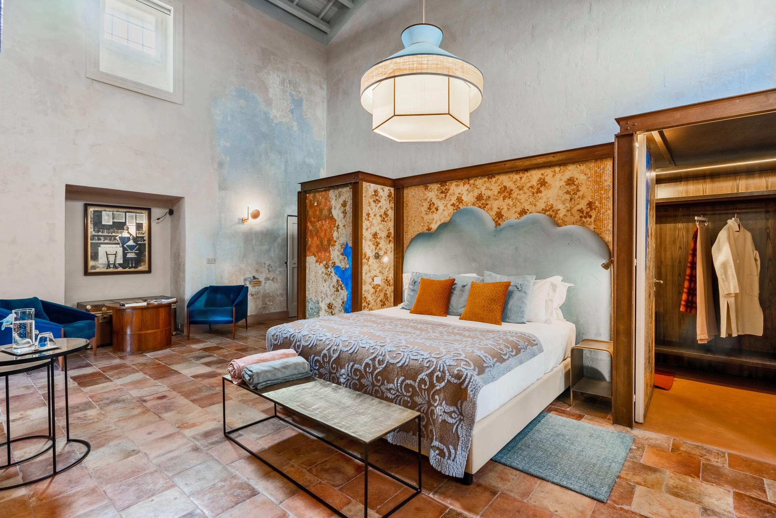 Spacious bedroom with high ceilings, artisanal decor and bespoke furniture in a luxury Italian villa