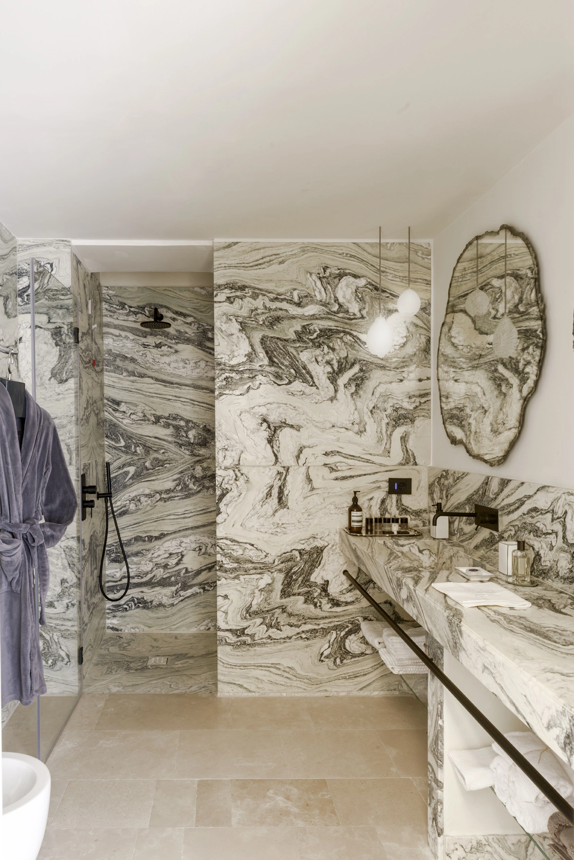 Elegant marble bathroom with bespoke vanity, walk-in shower, and soft ambient lighting in an Italian luxury residence