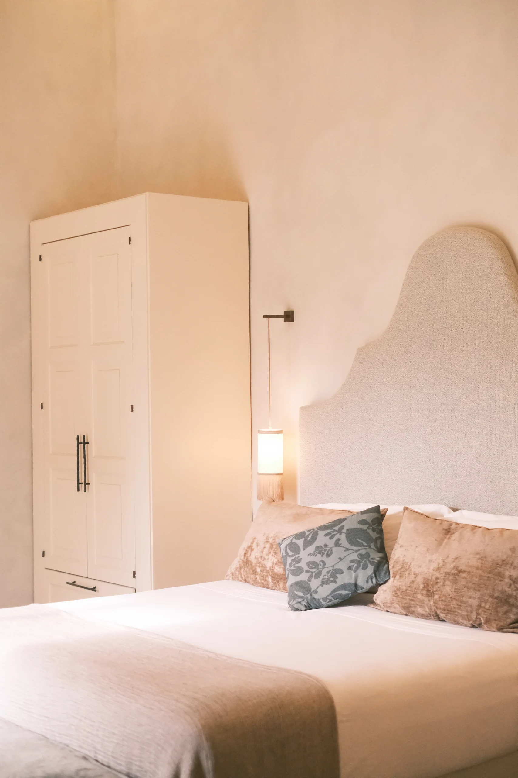 Bright luxury bedroom with arched ceilings, bespoke furniture, and curated art in Italy