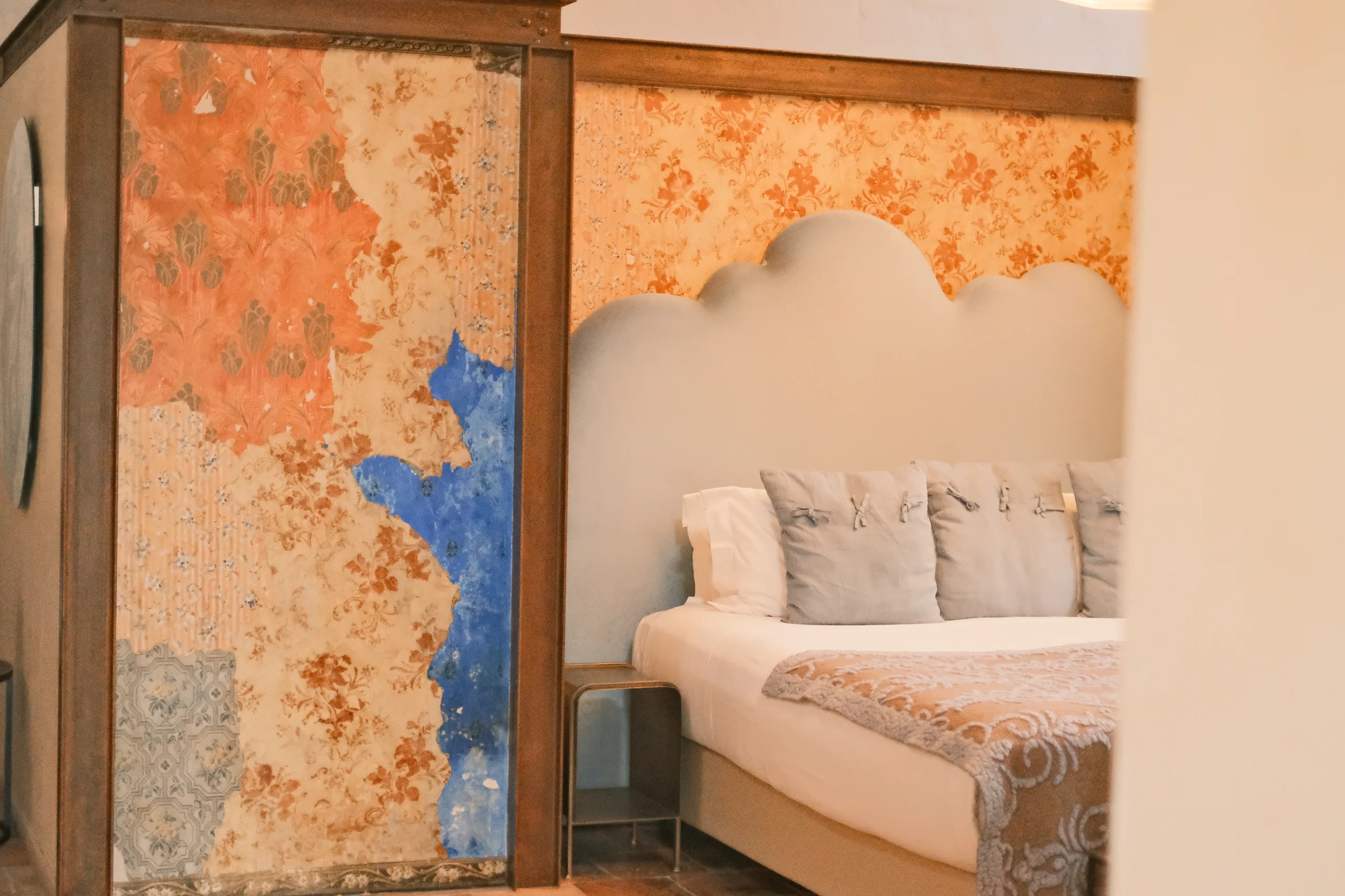Luxury bedroom with hand-painted fresco walls and sculpted headboard in an elegant Italian villa