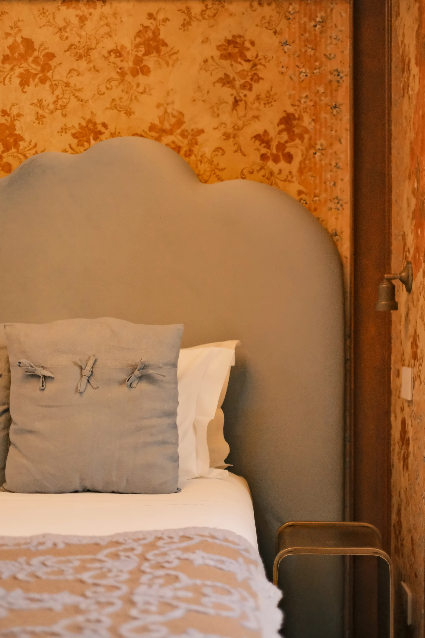 Close-up of bespoke headboard and textured cushions in a luxury villa bedroom in Italy