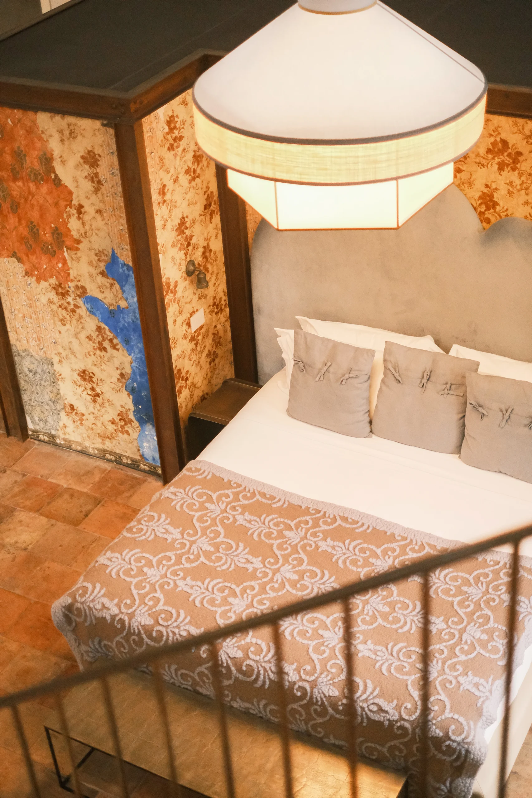 Elegant bedroom with custom pendant light and fresco-inspired walls in a boutique Italian villa