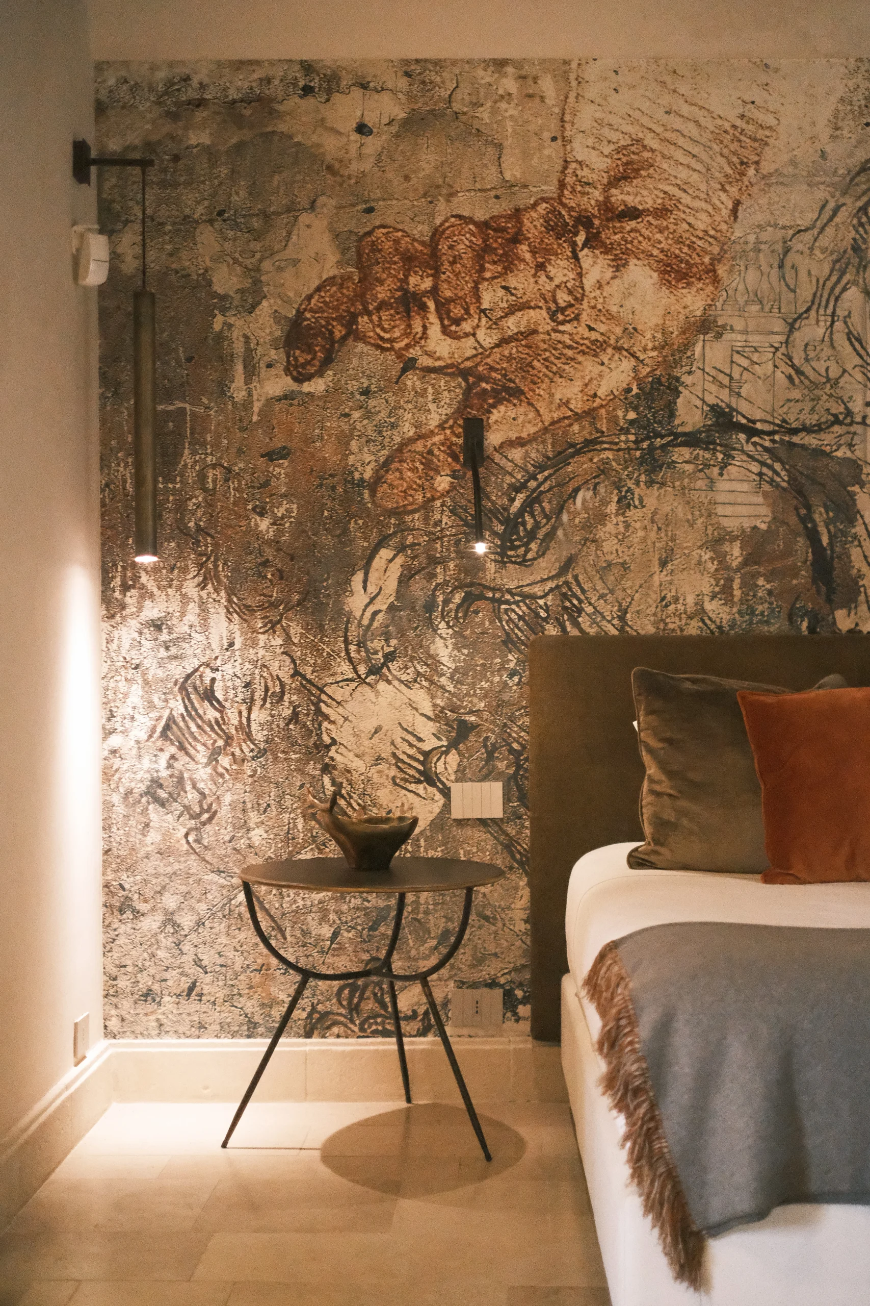 Artistic bedroom wall detail with sculptural lighting in a high-end Italian villa