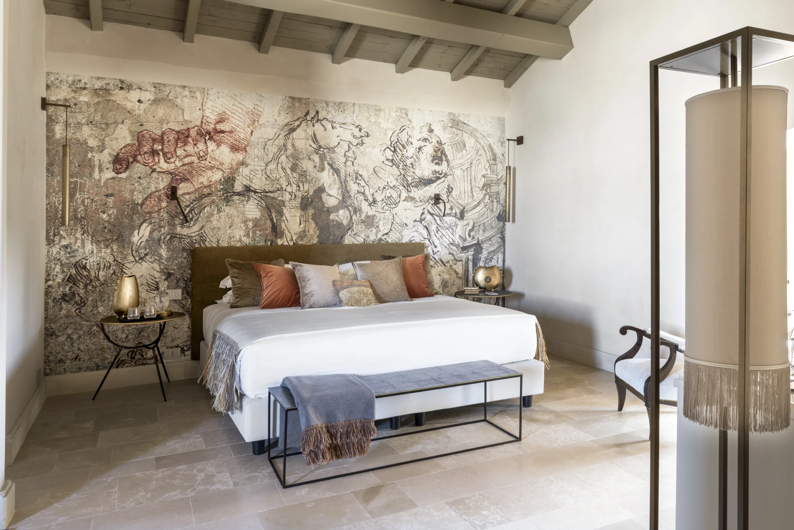 Luxury bedroom with bespoke mural wall art, king-size bed, and exposed wooden beams in a historic palazzo in Puglia