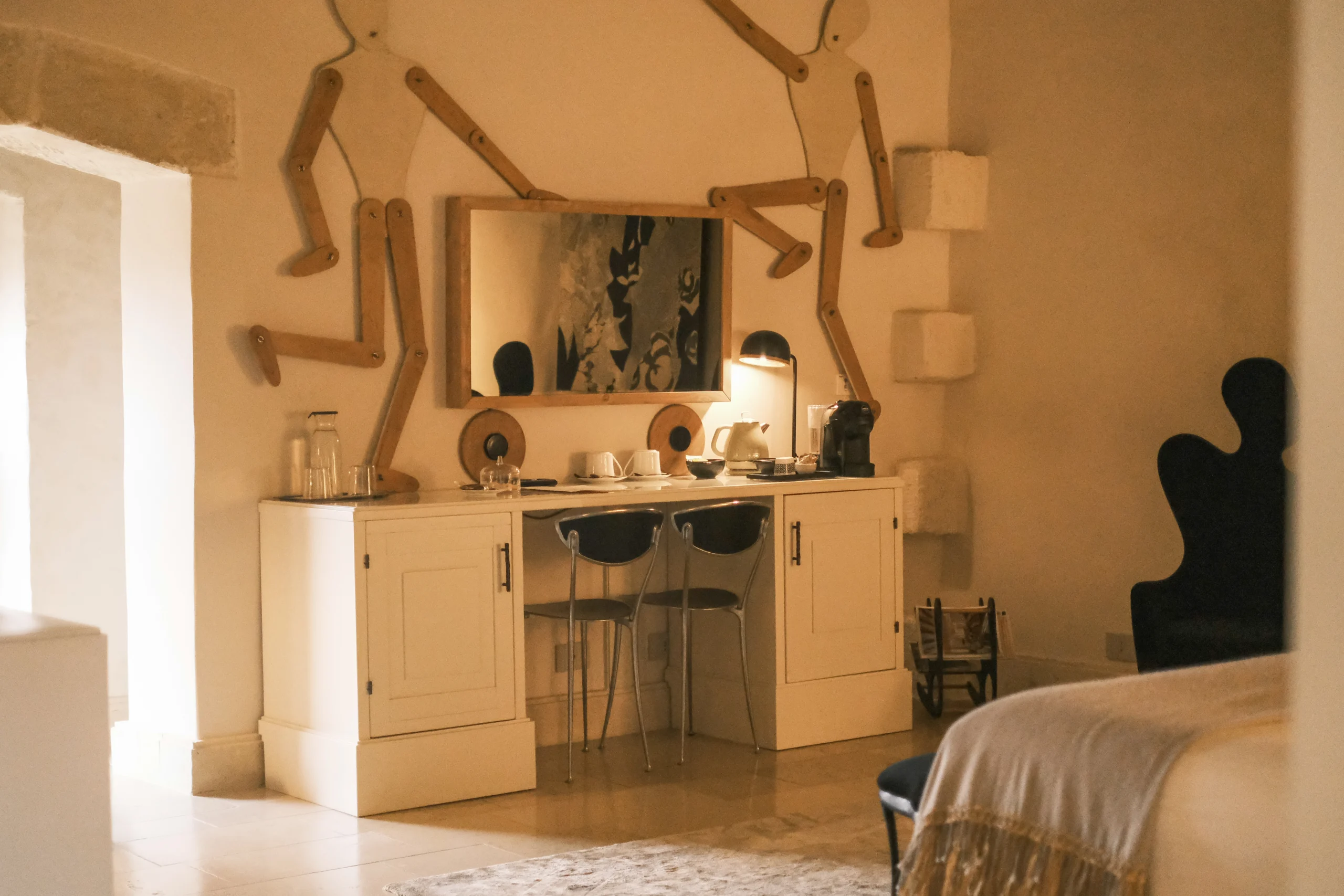 Designer vanity and writing desk with sculptural wall installation and soft lighting in a luxury Italian suite
