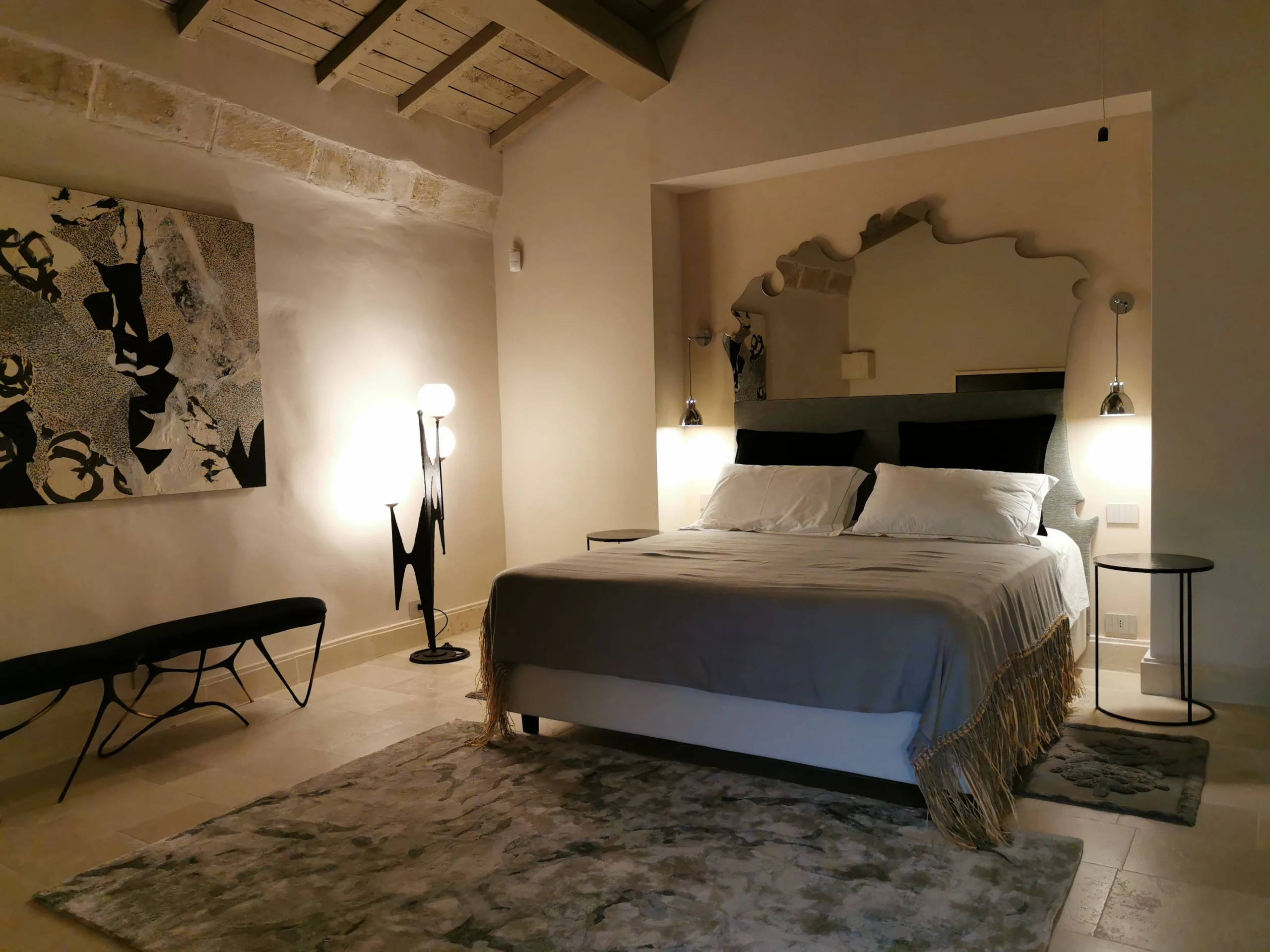Elegant bedroom with vaulted ceiling, contemporary lighting, and minimalist decor in a high-end Italian residence