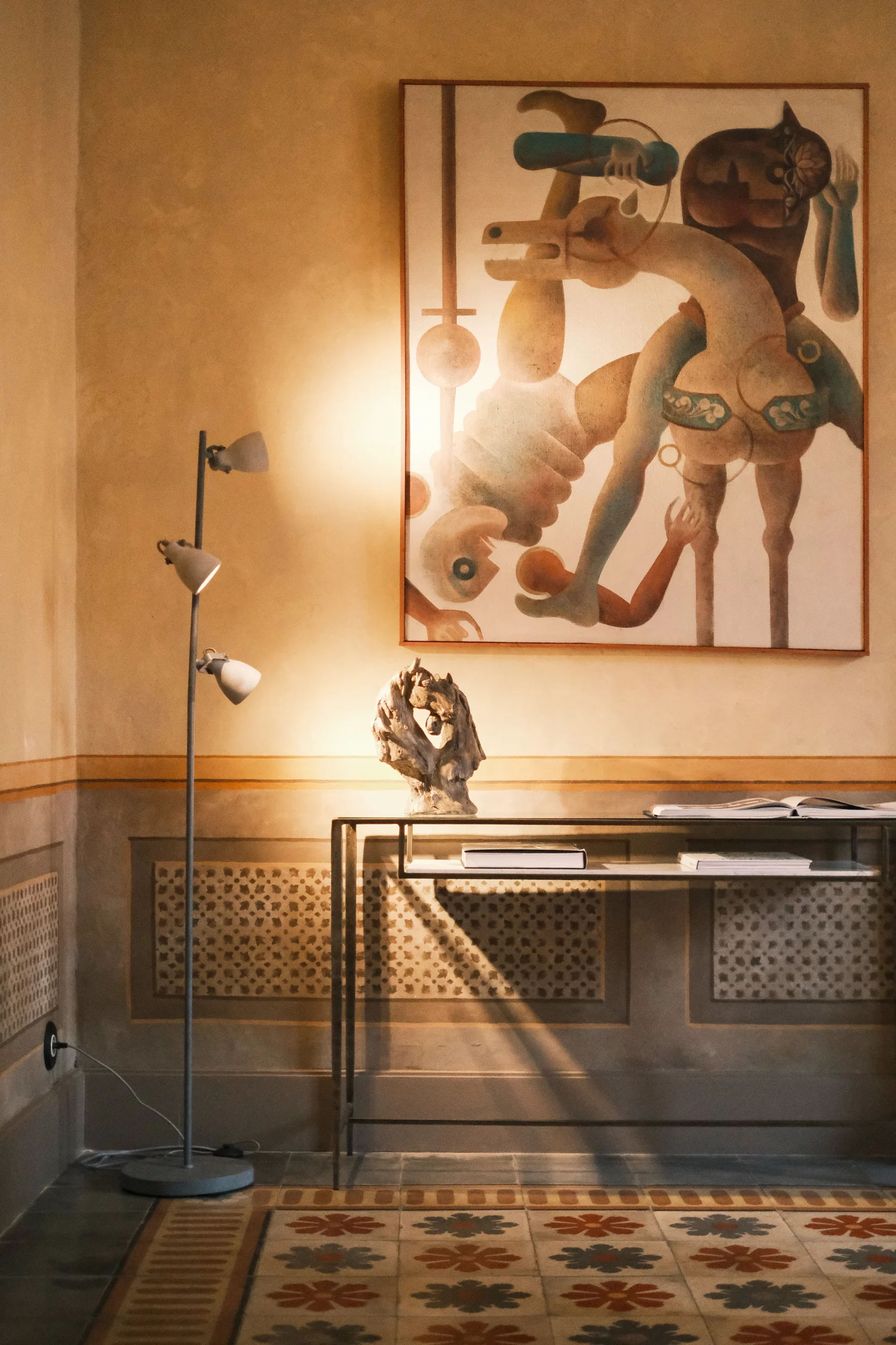 Elegant dining room in a historic palazzo in Lecce, featuring curated art, sculptural lighting, and original patterned cement tiles in Puglia