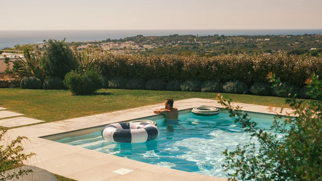 Person relaxing in a luxury swimming pool with unobstructed sea view in Puglia, exclusive villa experience