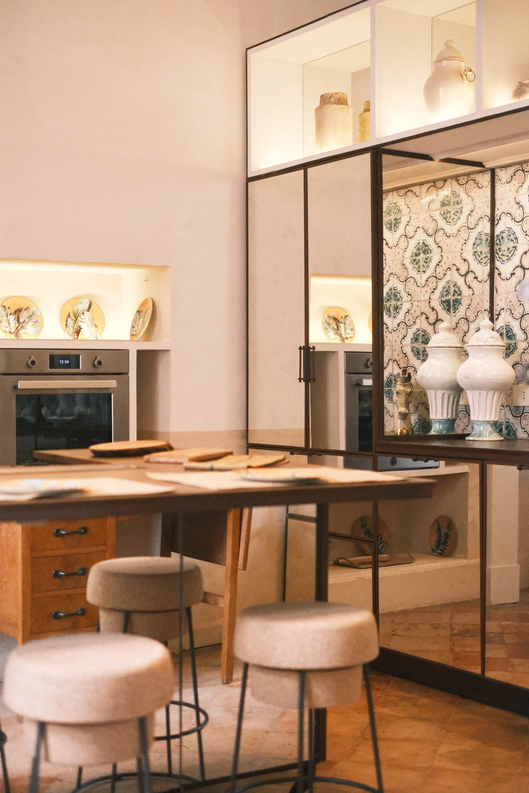 Close-up of a luxury kitchen island with stools, natural materials, and handcrafted details in a Puglia palazzo