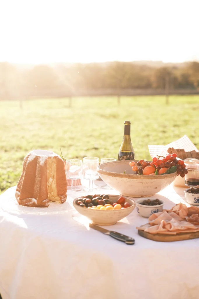 Sunlit Italian picnic table with traditional food and wine in a luxury villa garden in Puglia