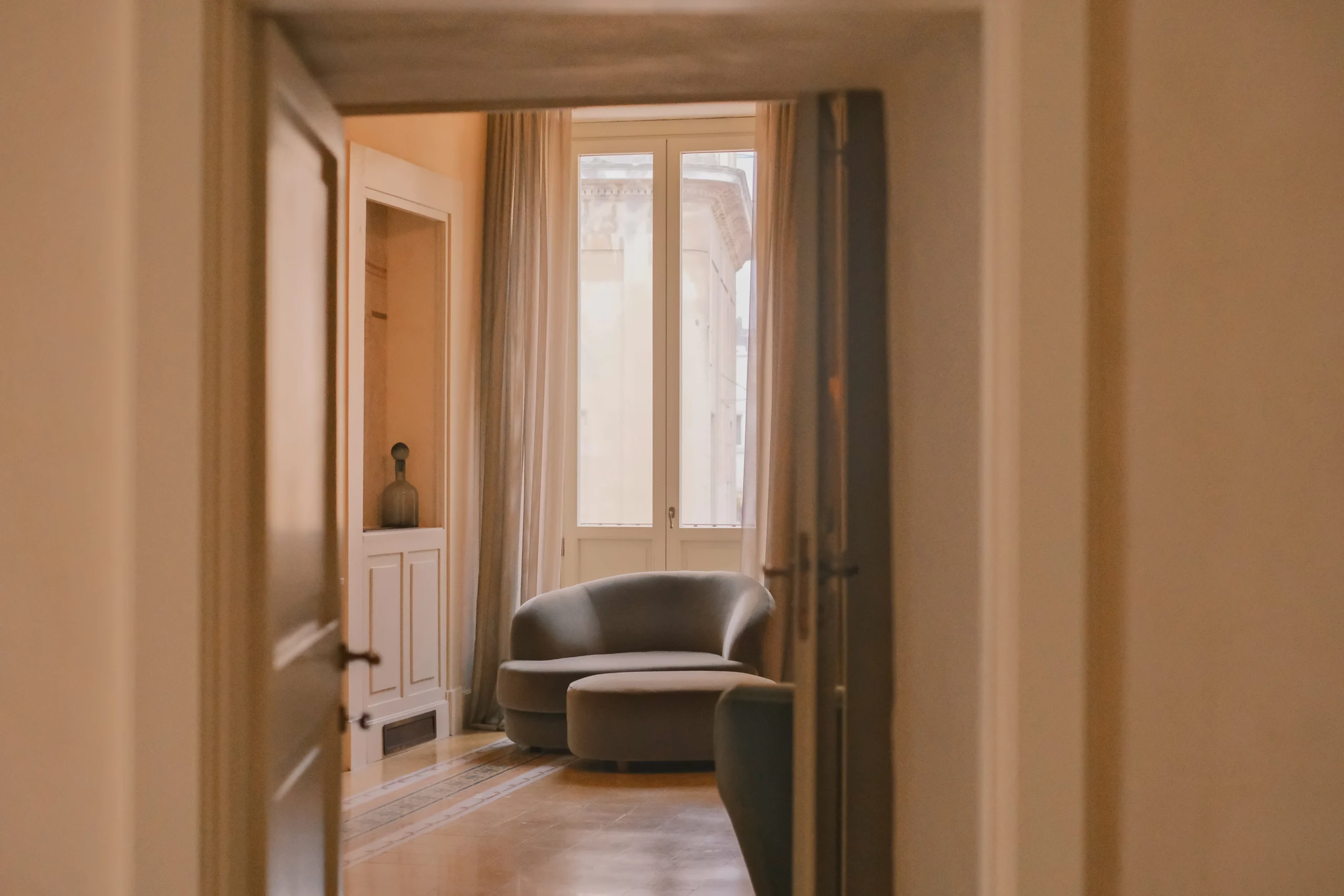 Stylish living room with curved sofa, art-driven decor, and warm lighting in a historic Italian property