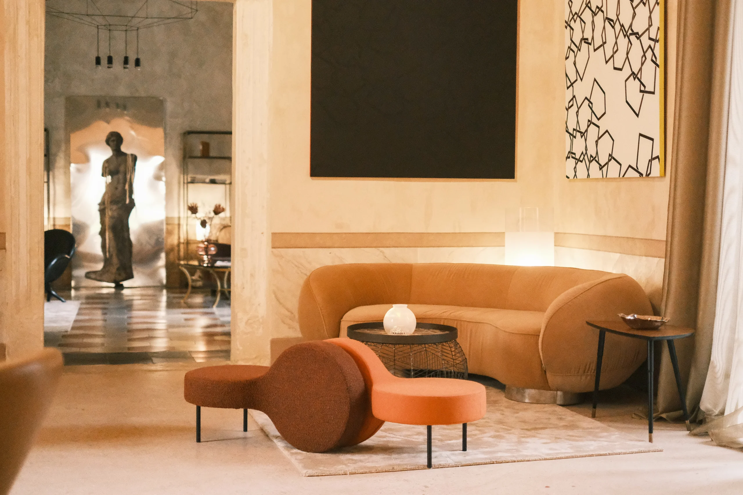 Luxury salon with sculptural furniture, abstract artwork, and soft neutral tones in a refined Italian interior