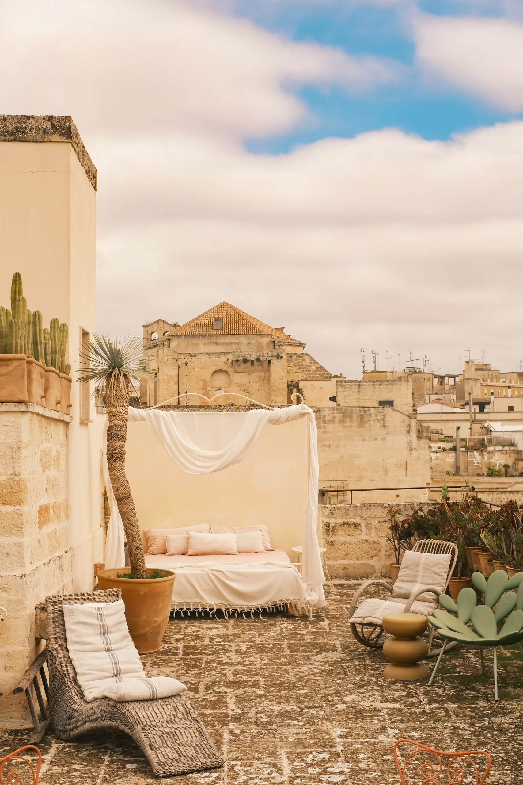 Luxury rooftop terrace with canopy daybed, lounge seating and panoramic views over Lecce old town in southern Italy