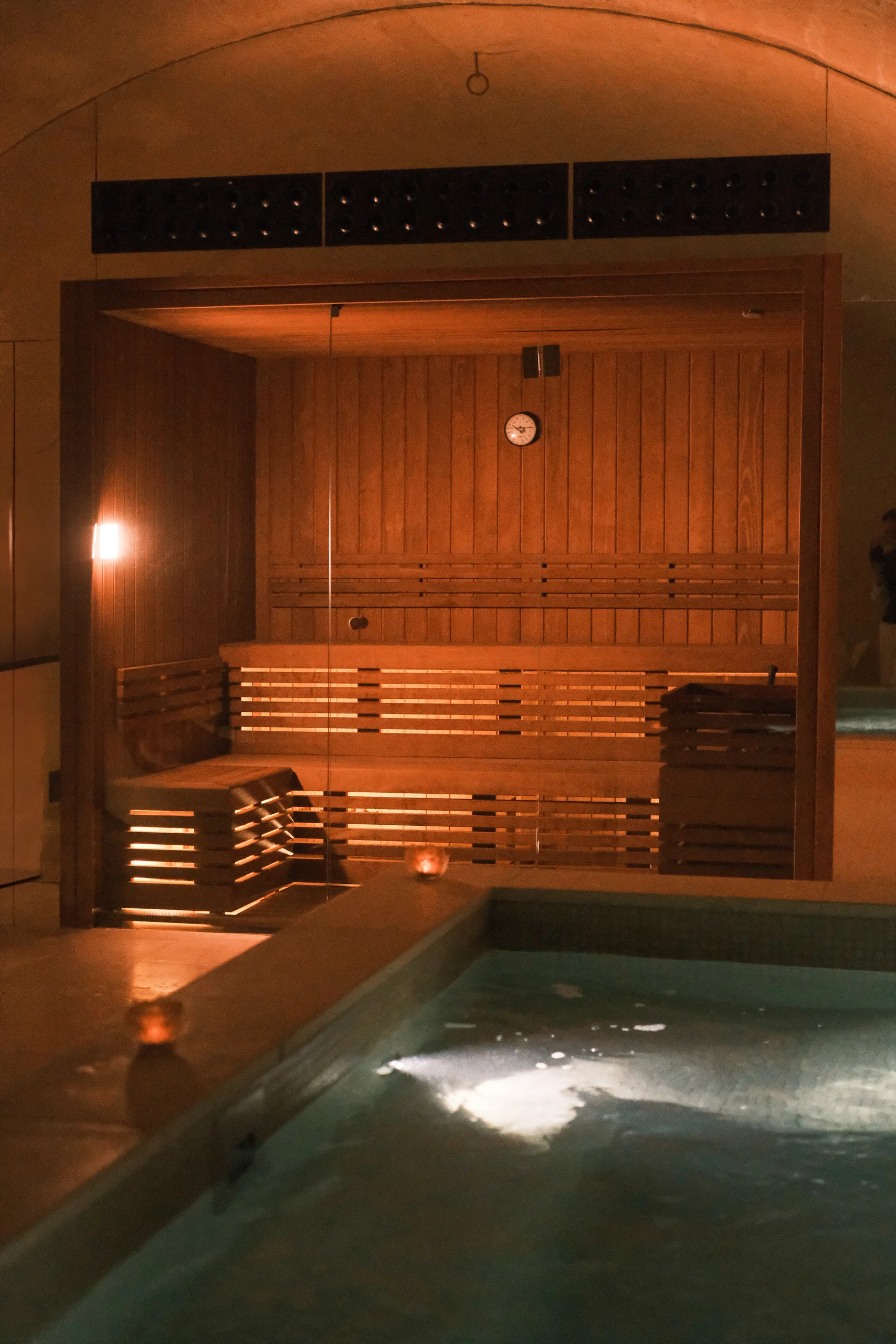 Luxury wooden sauna with soft lighting inside a historic stone spa in southern Italy