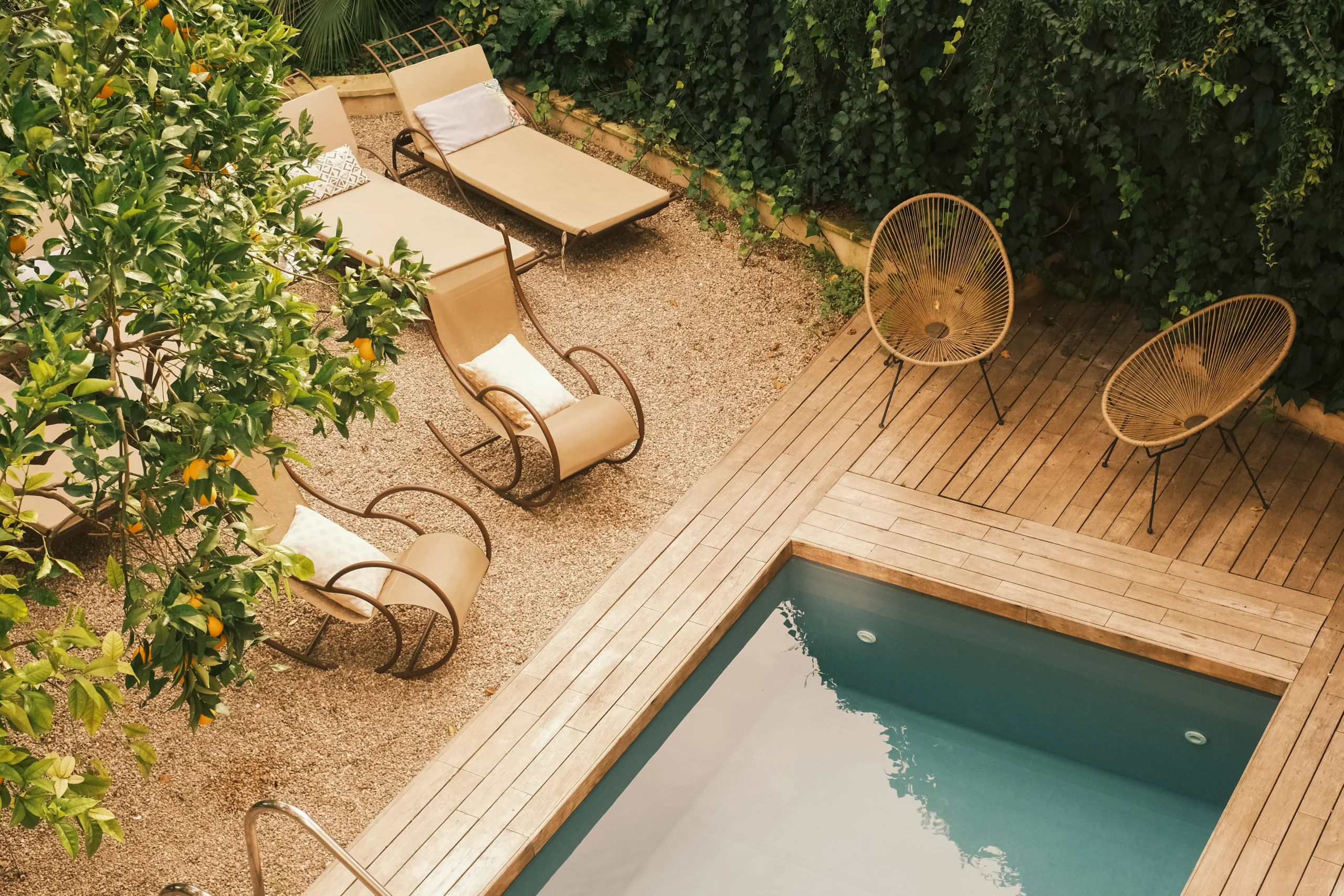 Private courtyard swimming pool with sun loungers, wooden deck and Mediterranean garden in a luxury villa in Puglia