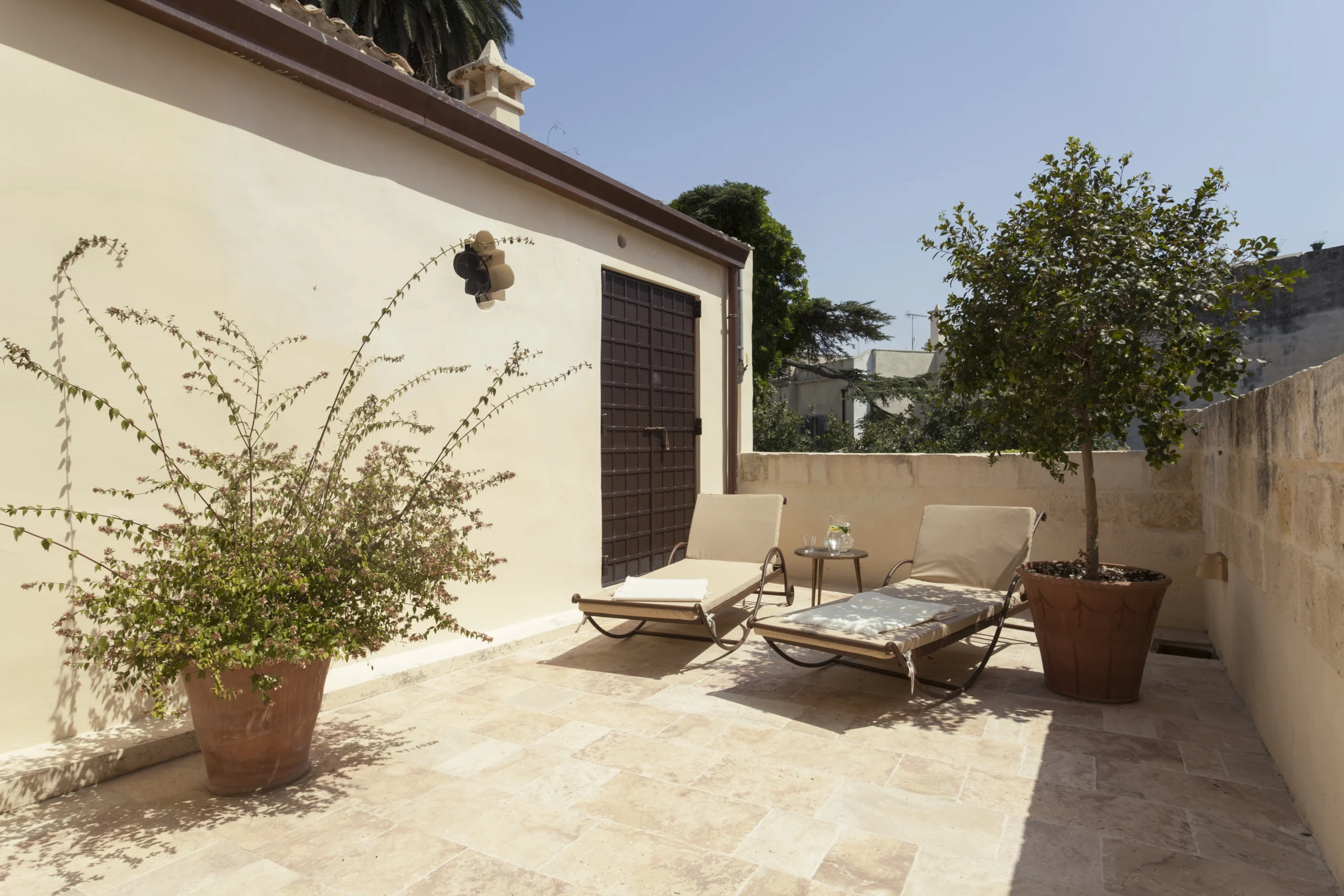 Private sun terrace with two loungers and Mediterranean plants at a luxury villa in Puglia, Italy