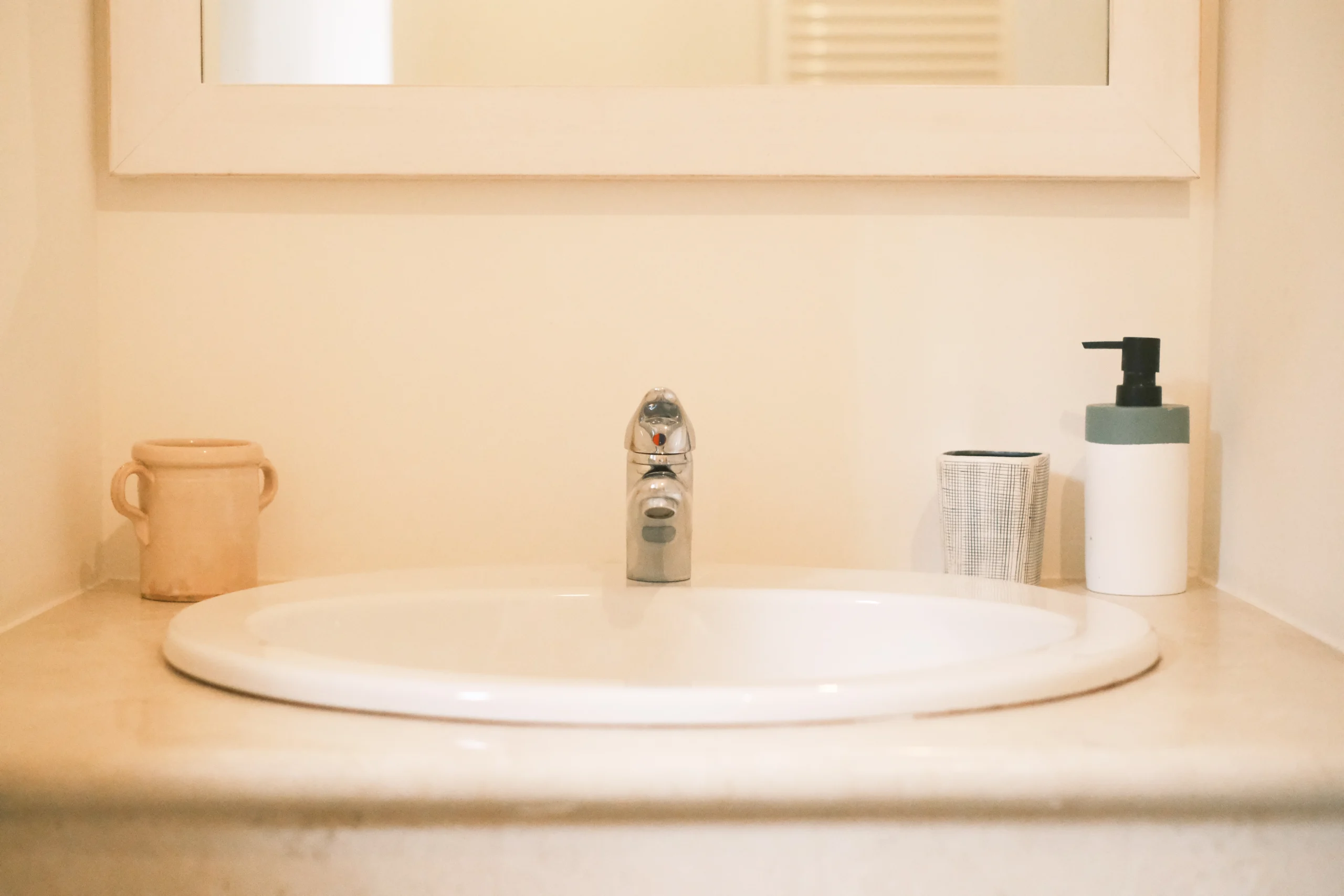 Minimalist bathroom sink with stone basin and soft lighting at luxury villa in Puglia