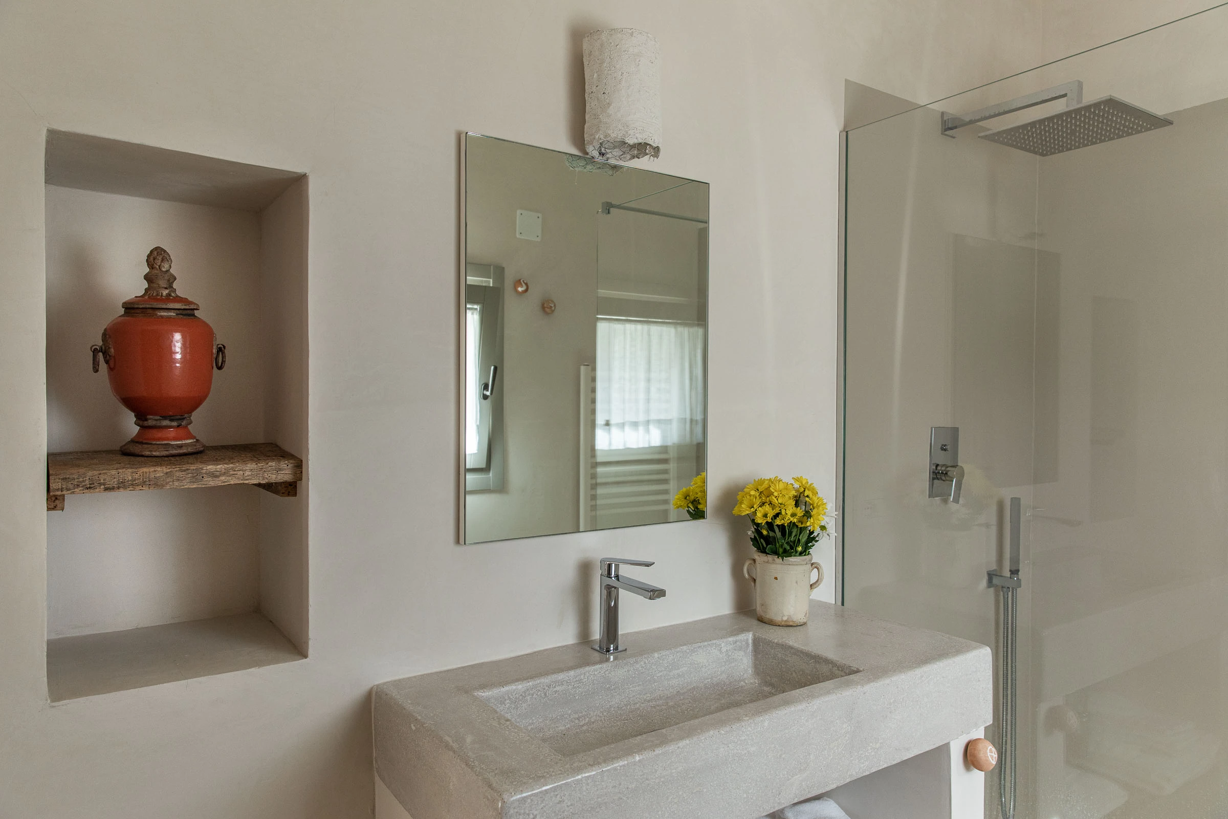 Elegant bathroom with stone vanity, walk-in shower and natural materials in Puglia villa