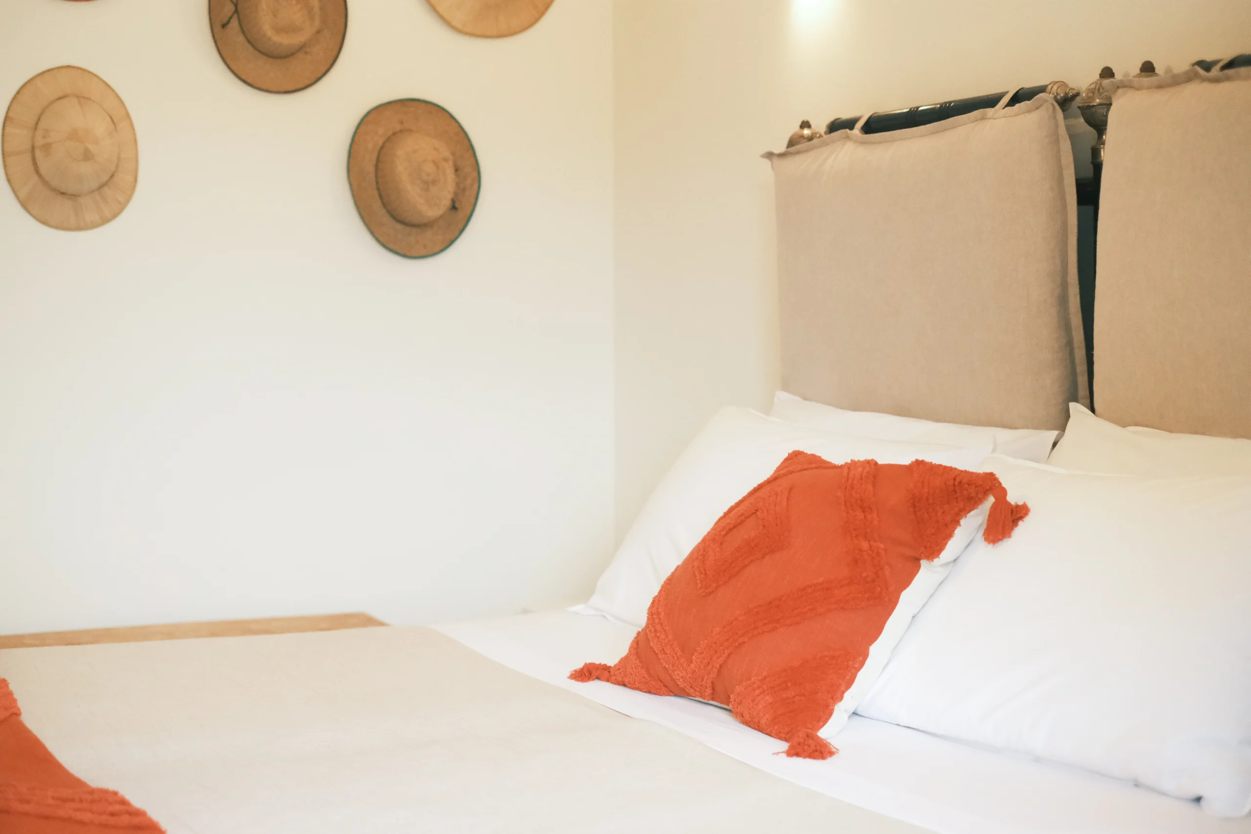 Detail of double bed with handcrafted cushions and soft neutral tones in Puglia villa