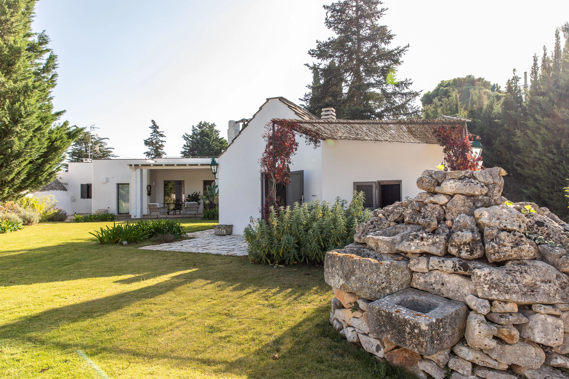 Private garden view with historic chapel building and stone pathway at luxury villa in Puglia