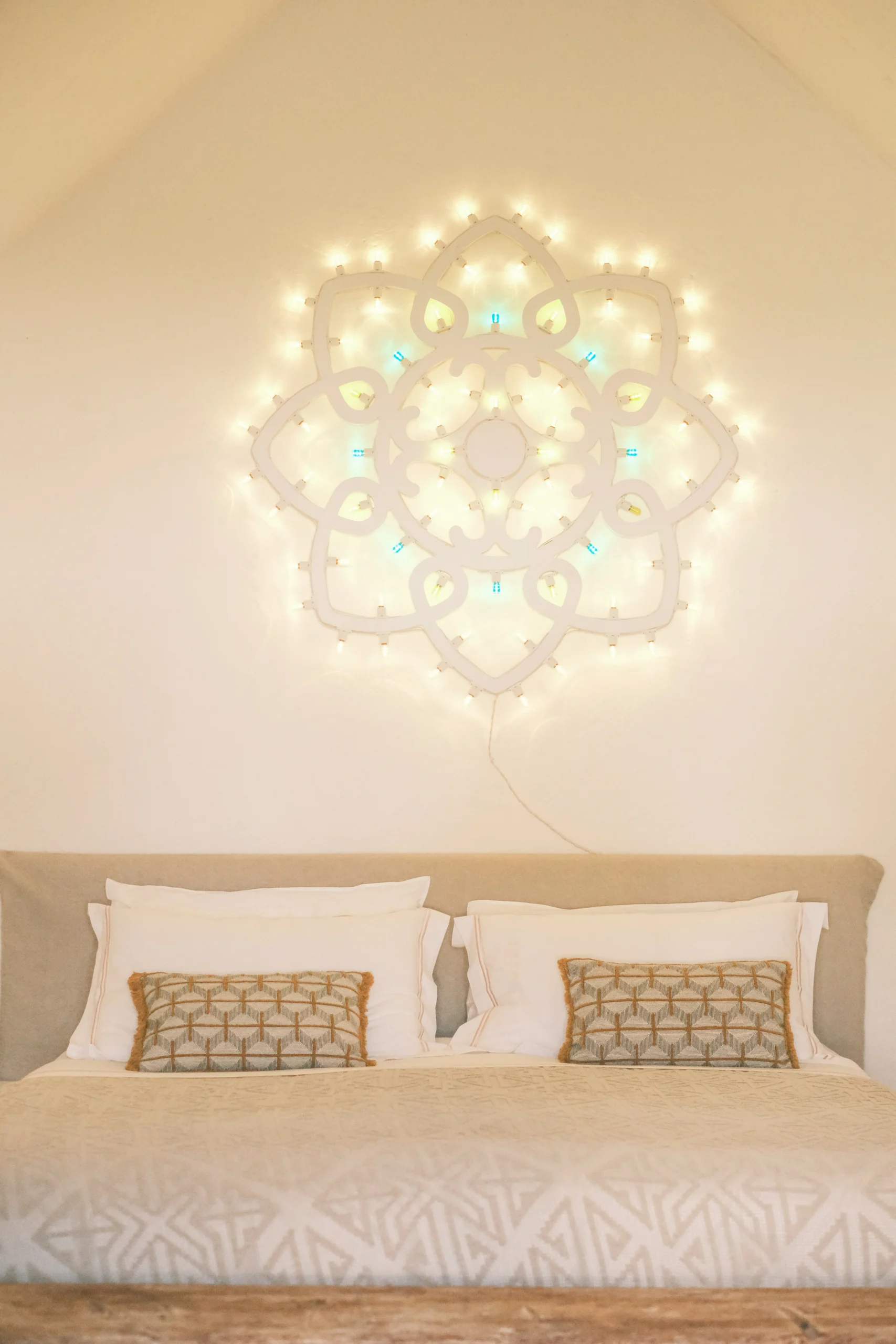 Chapel bedroom with symmetrical bed, artisan textiles and soft ambient lighting in luxury villa in Puglia
