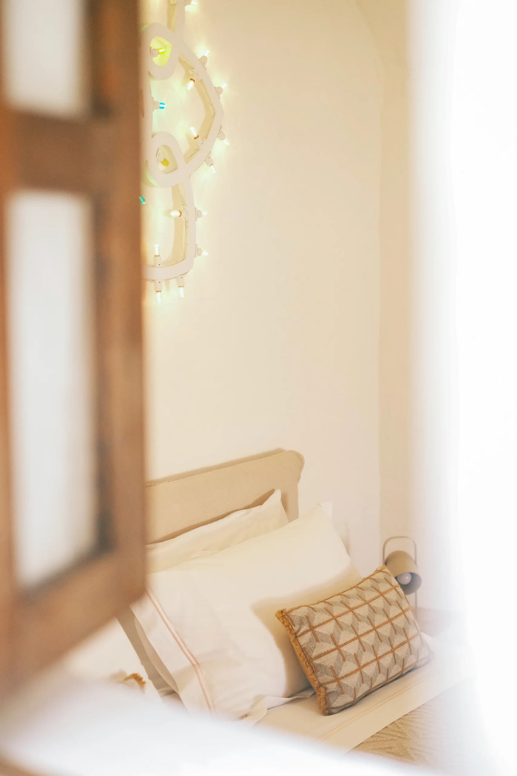 Intimate chapel room detail with artistic lighting feature and refined bedding at luxury villa in Puglia