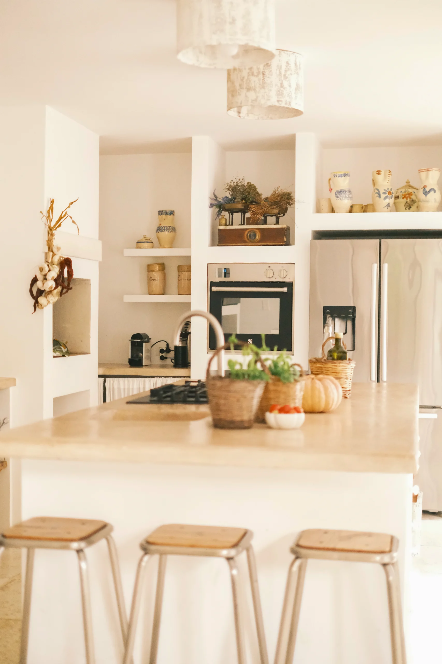 Bright Mediterranean kitchen with stone island, wooden stools and handcrafted ceramics at Villa Caterina in Puglia