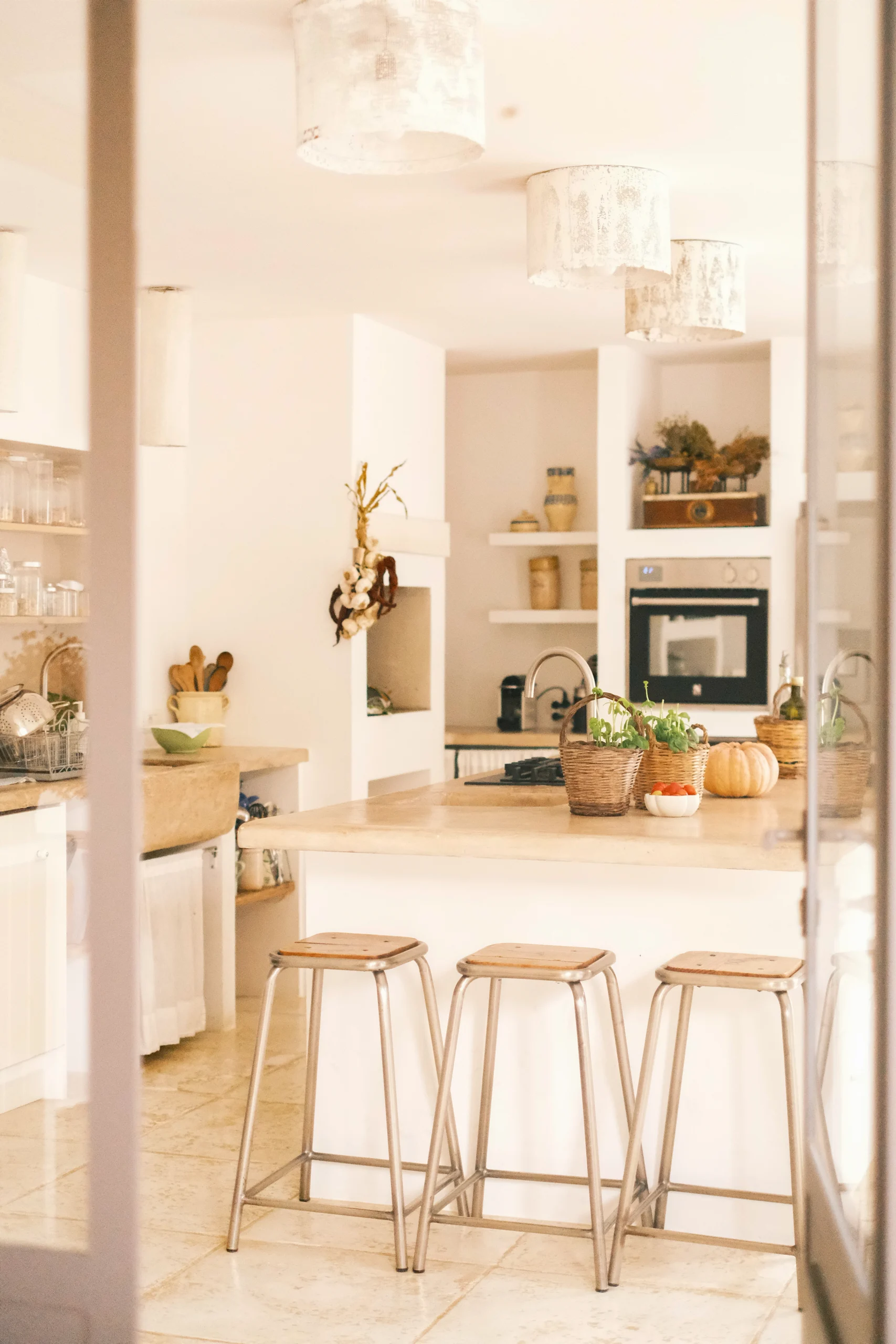 View into a sunlit Mediterranean kitchen with stone island and vintage details at Villa Caterina in southern Italy