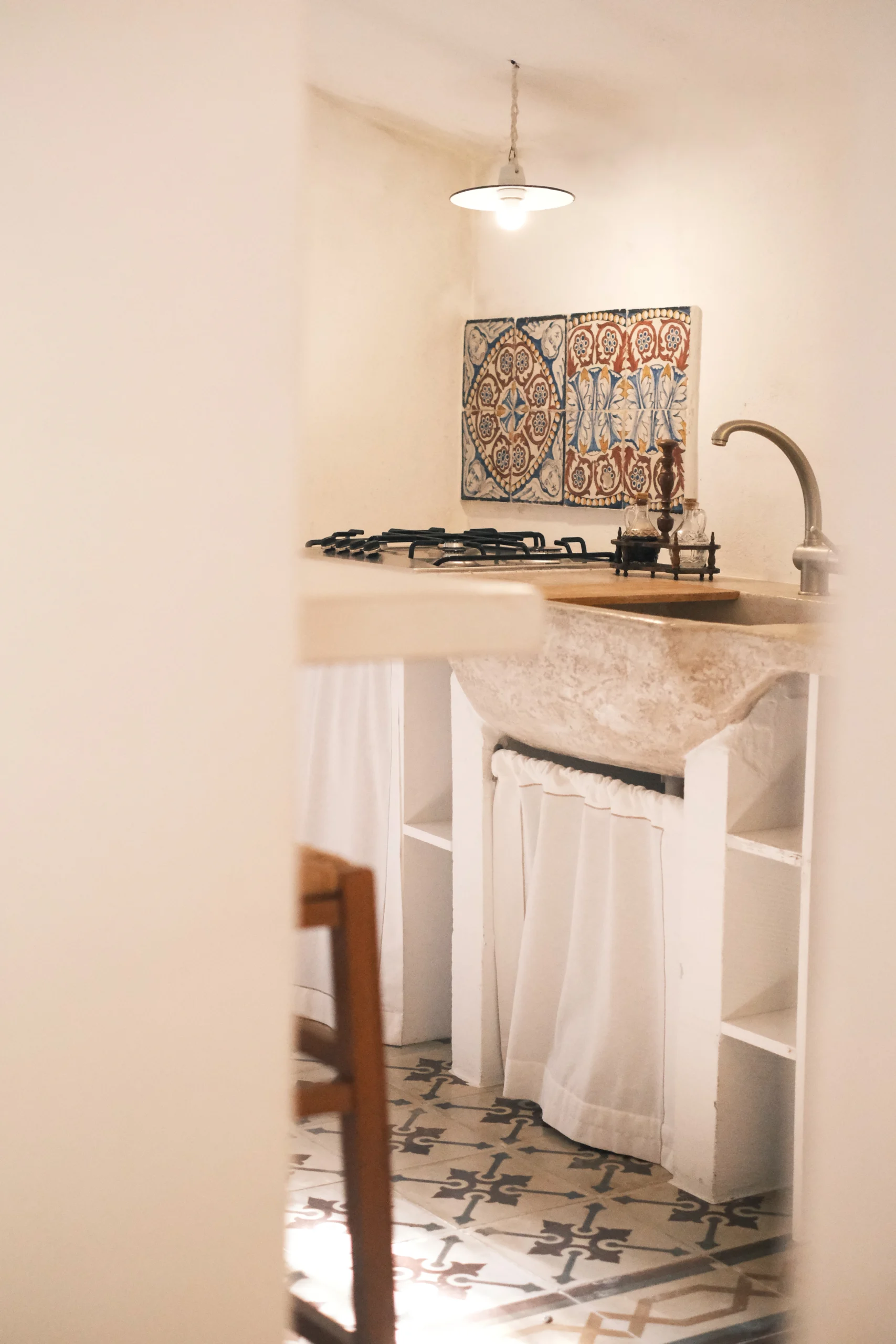 Detail of the authentic kitchen with stone basin and hand-painted tiles in a luxury villa in Puglia