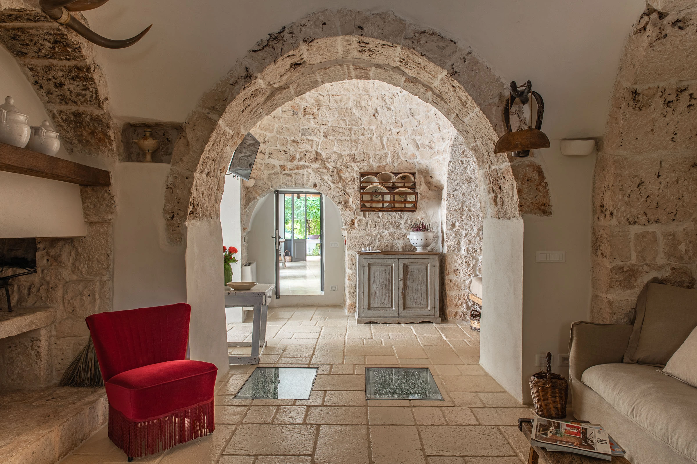 Historic living room with stone arches and vaulted ceiling in a restored Puglian villa