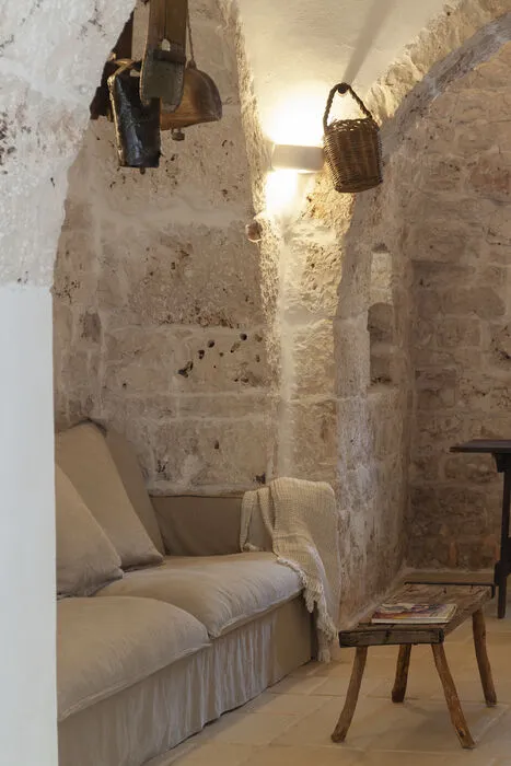 Cozy lounge area with stone walls, soft lighting and traditional Apulian architecture