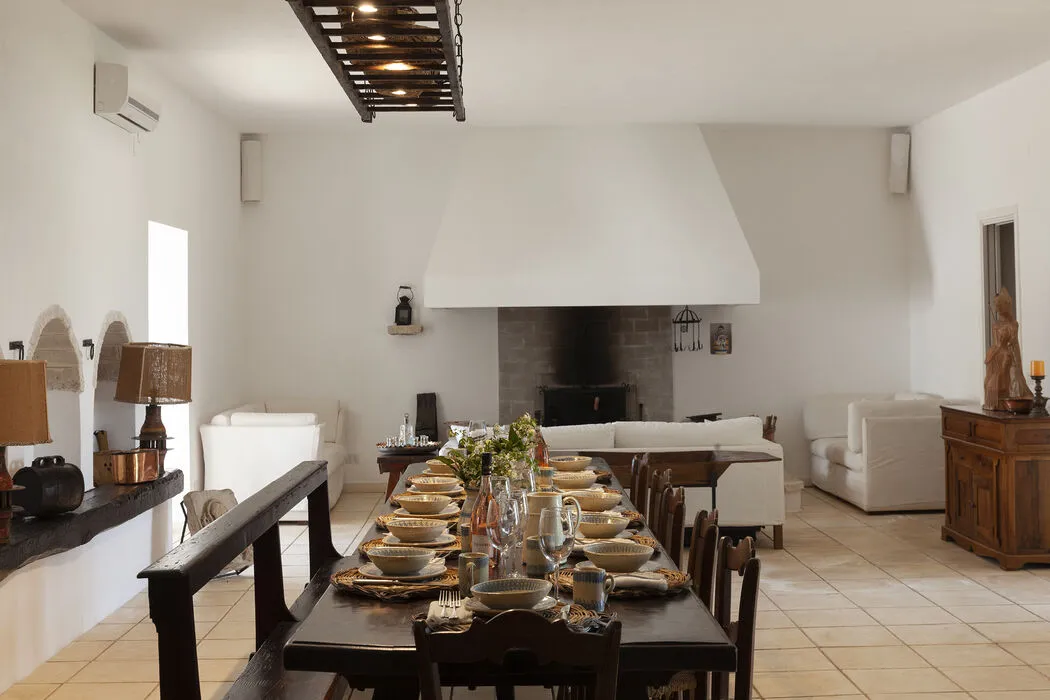 Evening view of a fireplace lounge with sofas in a refined countryside villa in southern Italy