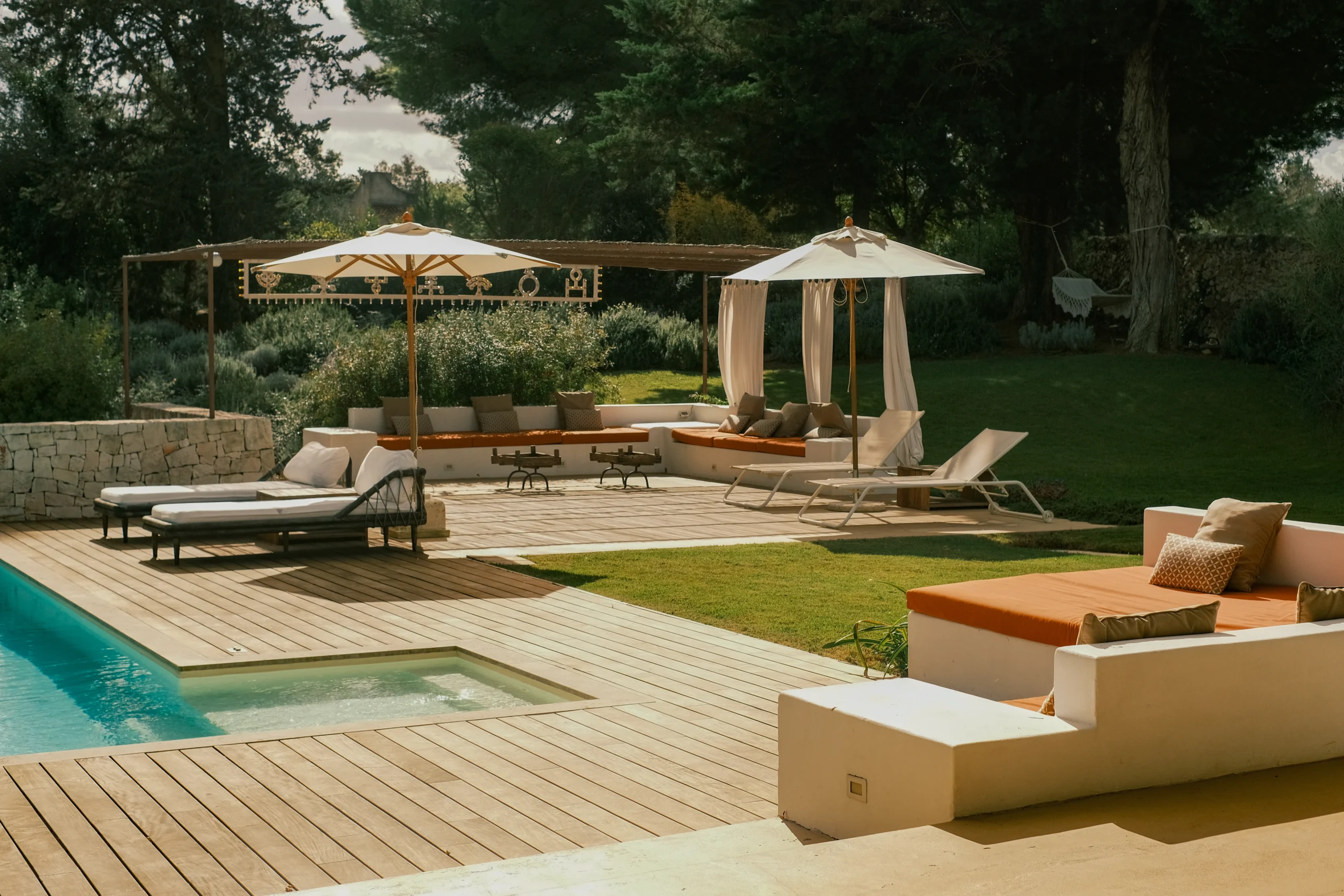 Elegant outdoor lounge area with pool, sunbeds and pergola in a luxury villa garden in Puglia