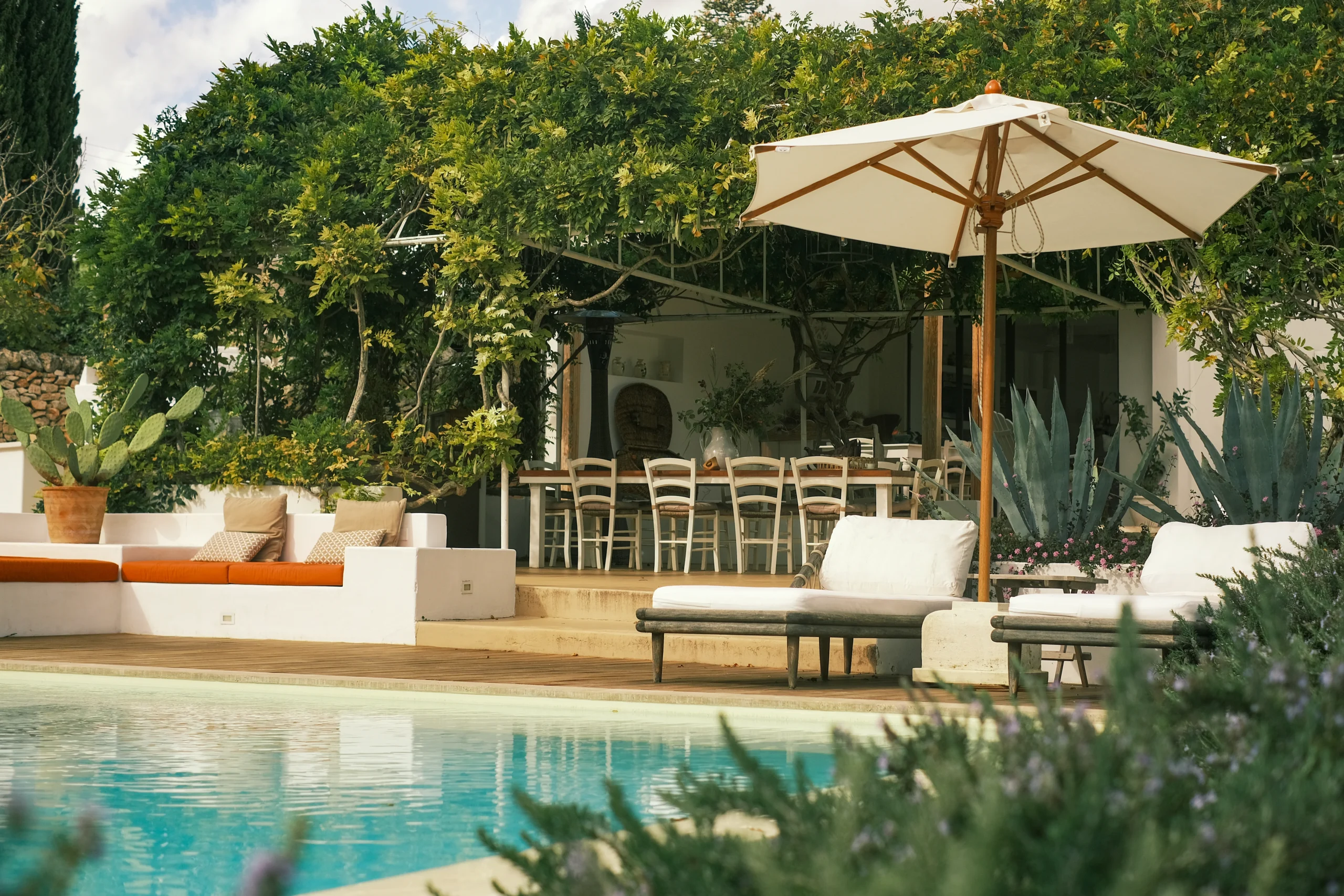 Outdoor dining and lounge area overlooking a swimming pool in an elegant private villa in Puglia