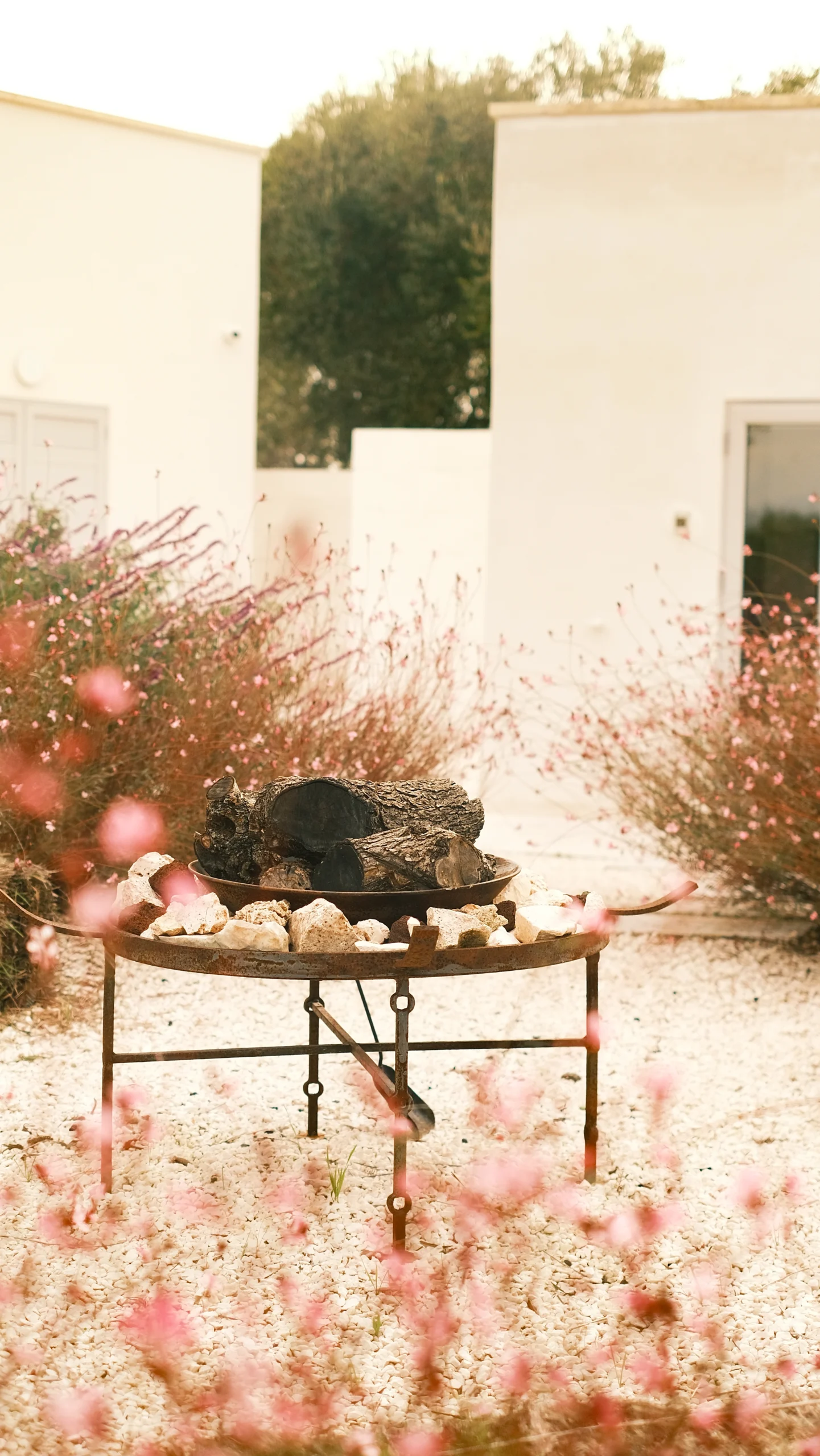 Outdoor fire pit surrounded by Mediterranean plants in the garden of a luxury villa in Puglia