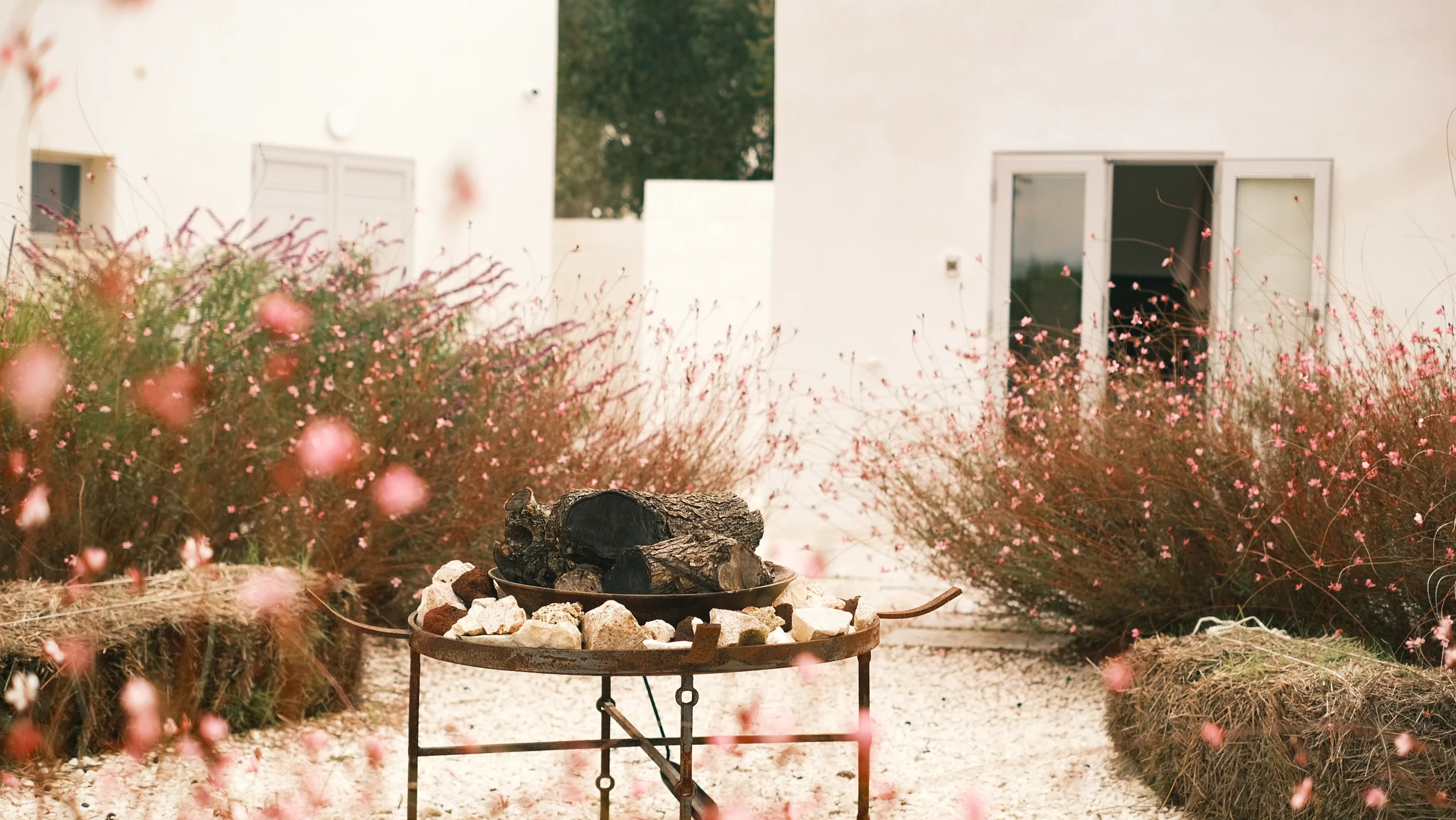 Rustic outdoor brazier set in a private garden with white architecture in Puglia