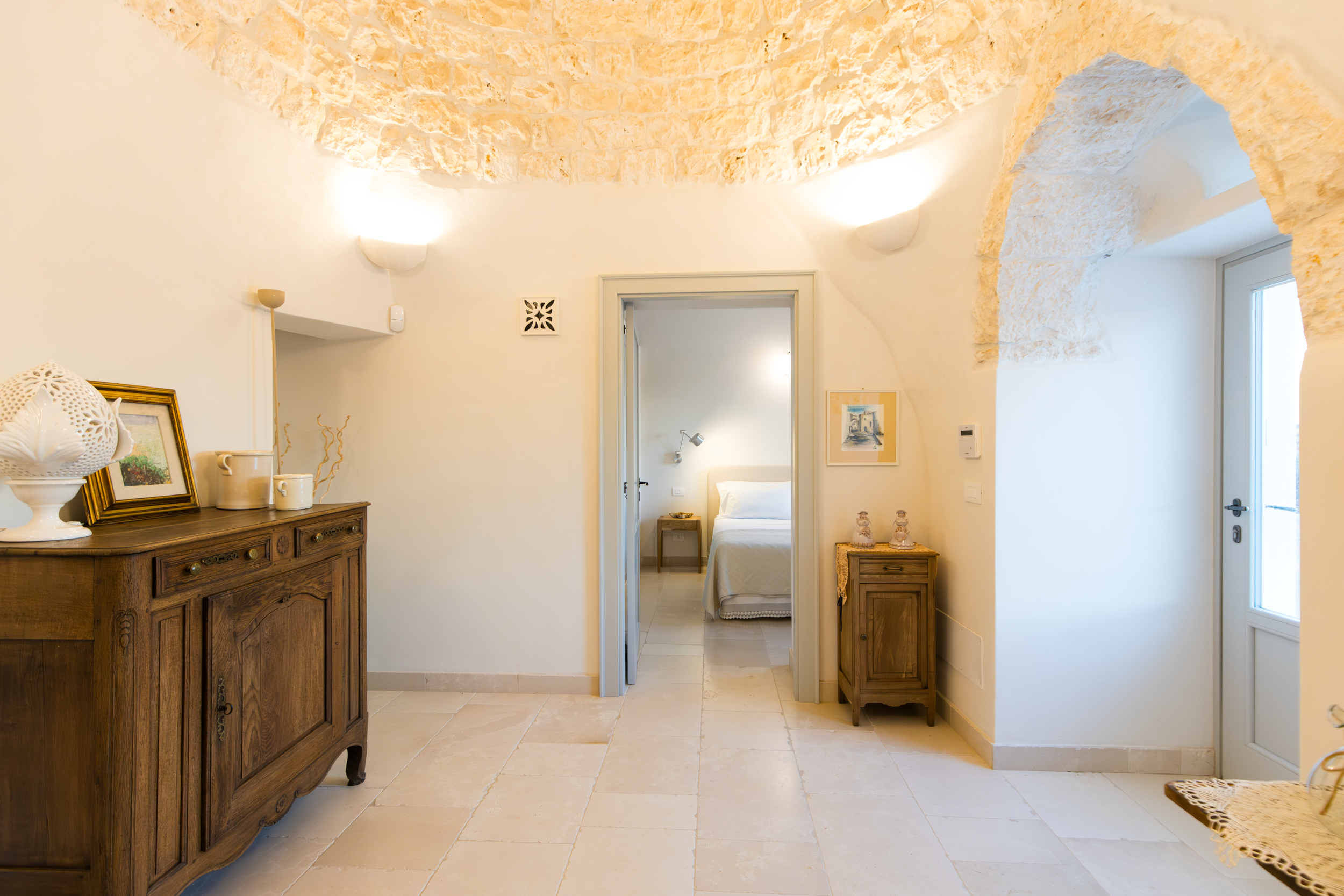 Elegant interior hallway with arched stone ceiling and traditional furniture in a luxury villa in Puglia