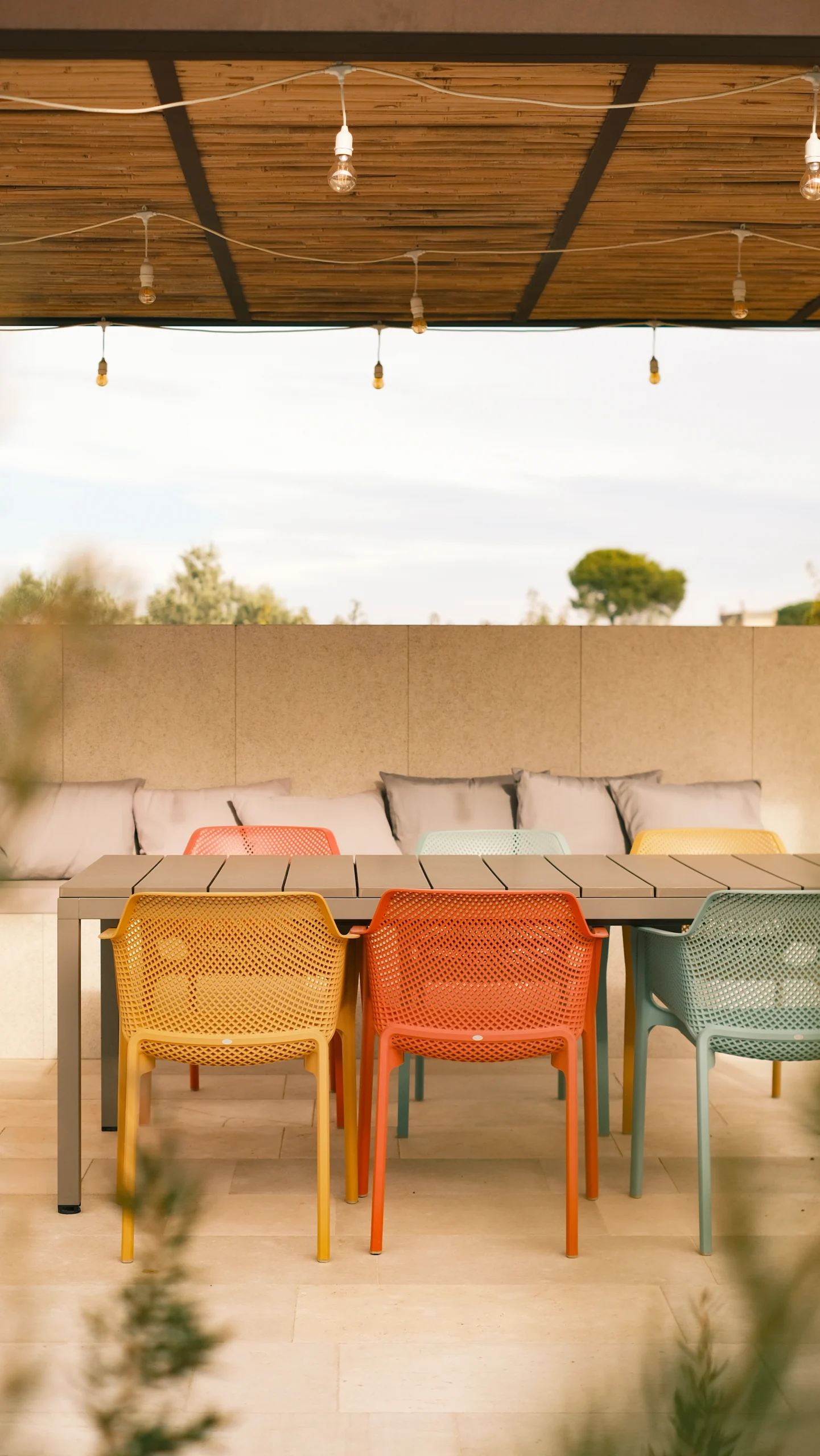 Outdoor dining table under pergola with designer chairs in a luxury villa in Puglia