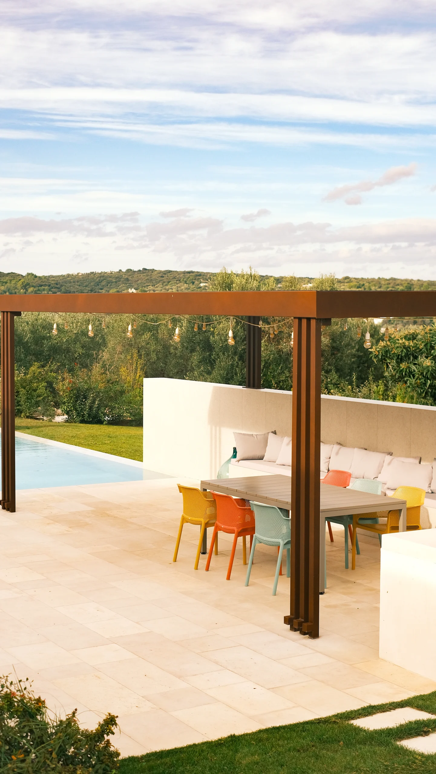 Covered outdoor dining area with large table and lounge seating in a Puglia luxury villa