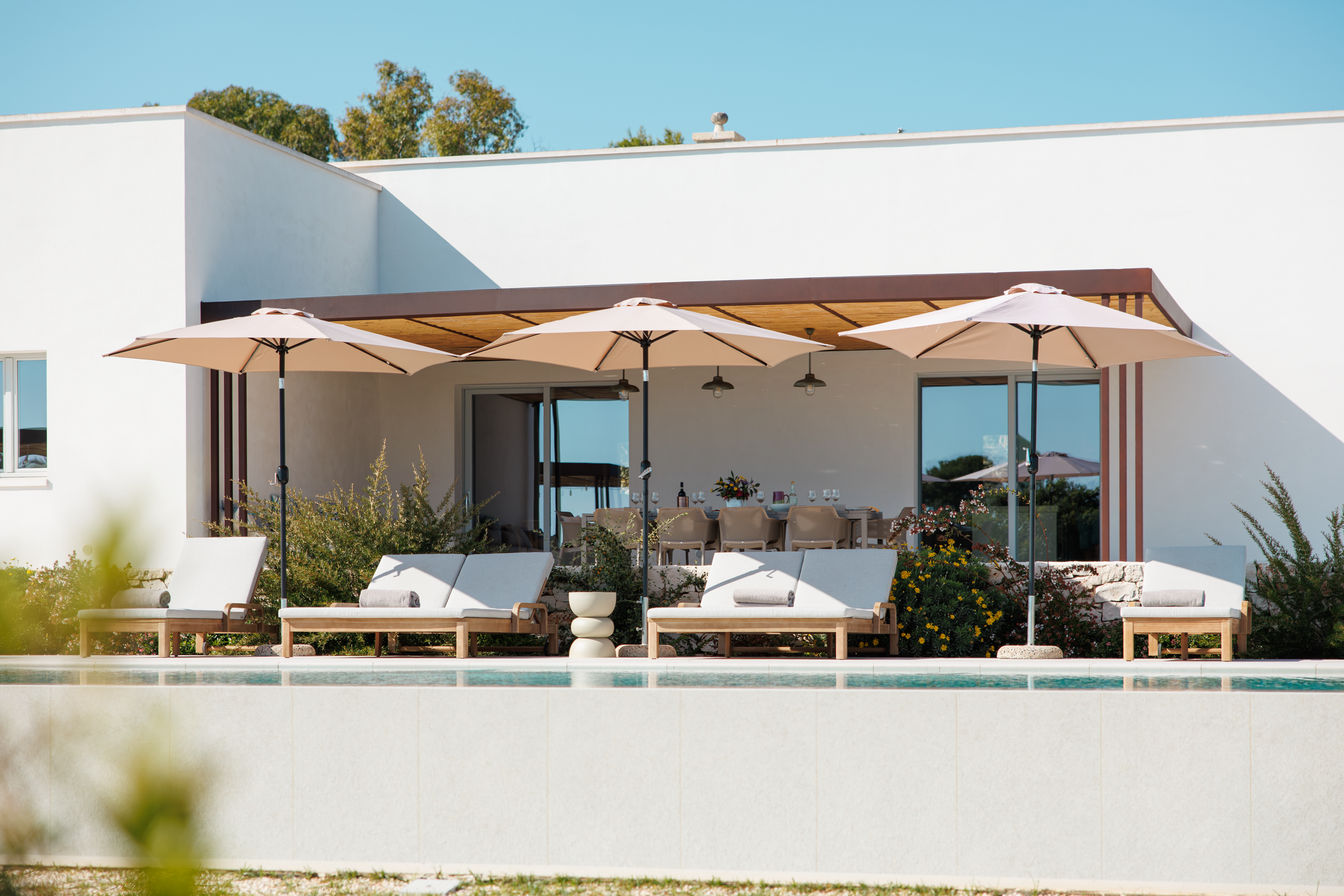 Poolside terrace with sun loungers and umbrellas in a luxury villa in Puglia