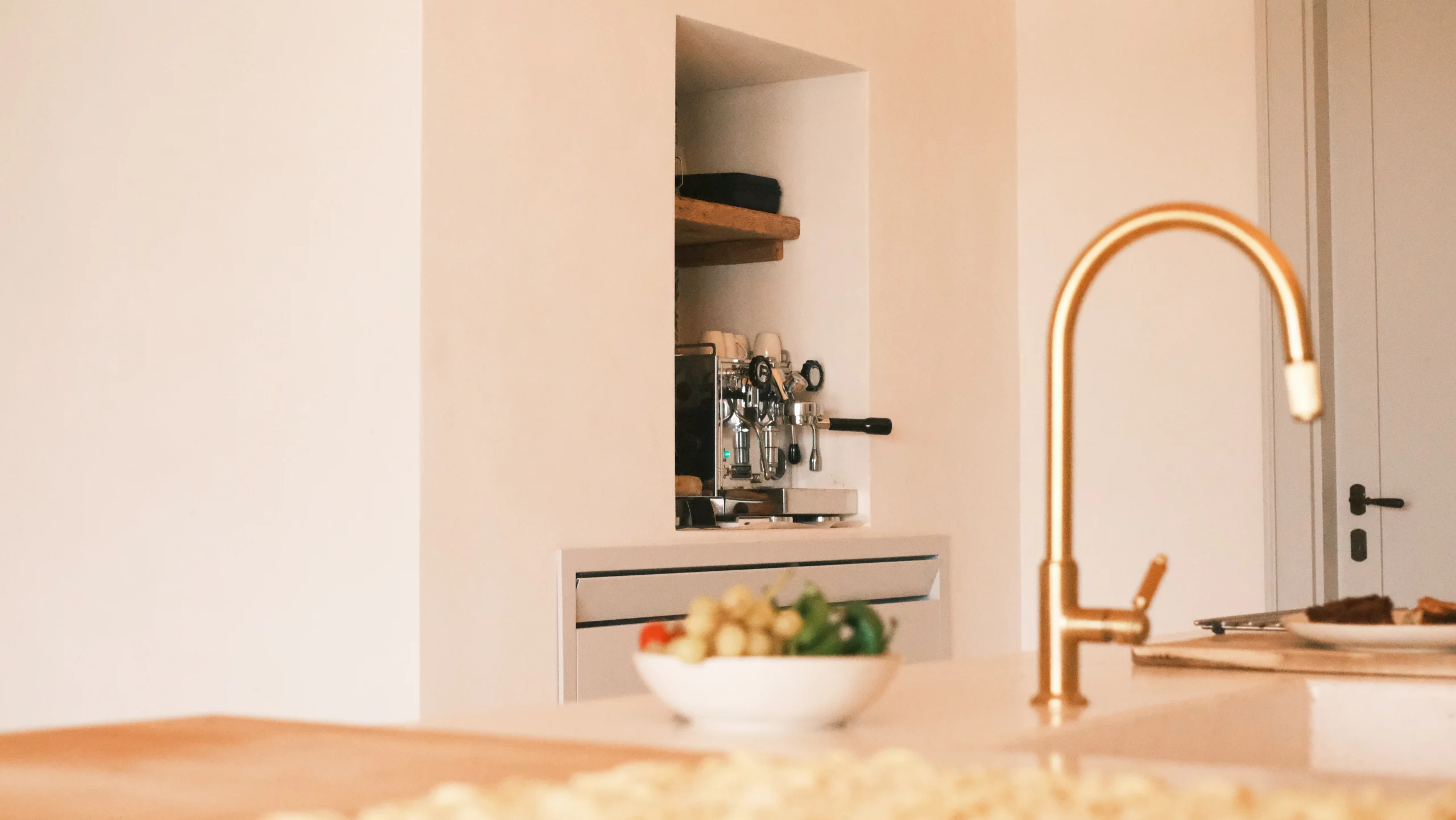 Stone kitchen island with brass tap and built-in espresso machine in a high-end trullo villa