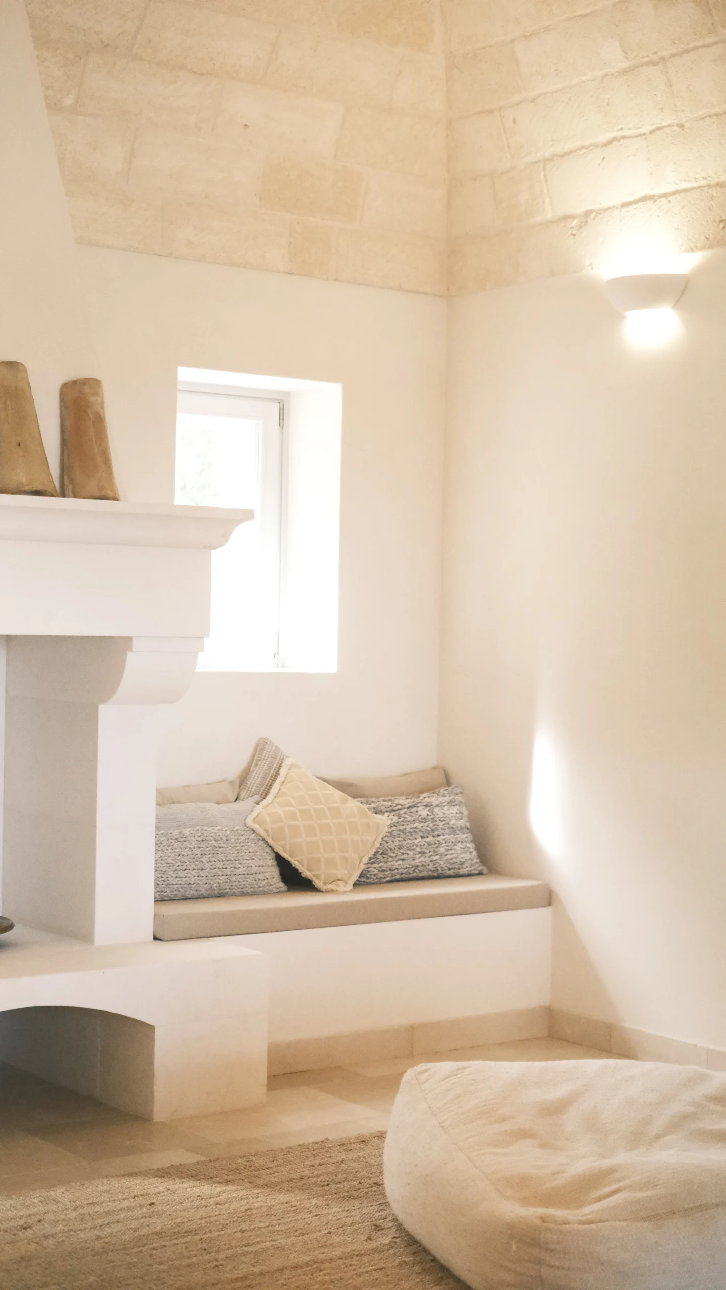 Cozy lounge area with stone ceiling, fireplace and natural light in a refined trullo living room