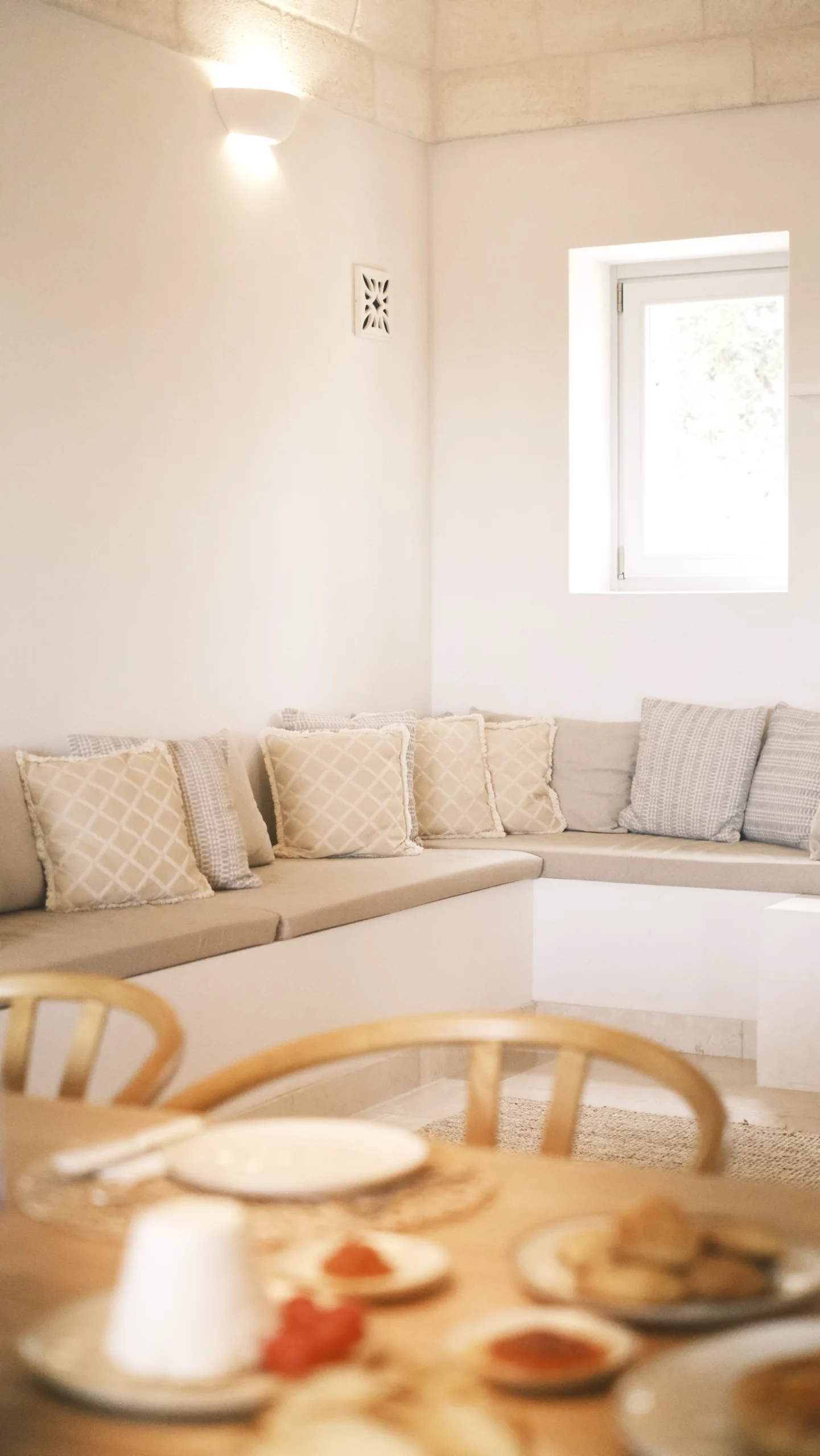 Built-in seating area with soft cushions and stone ceiling in a luxury villa living room in Puglia