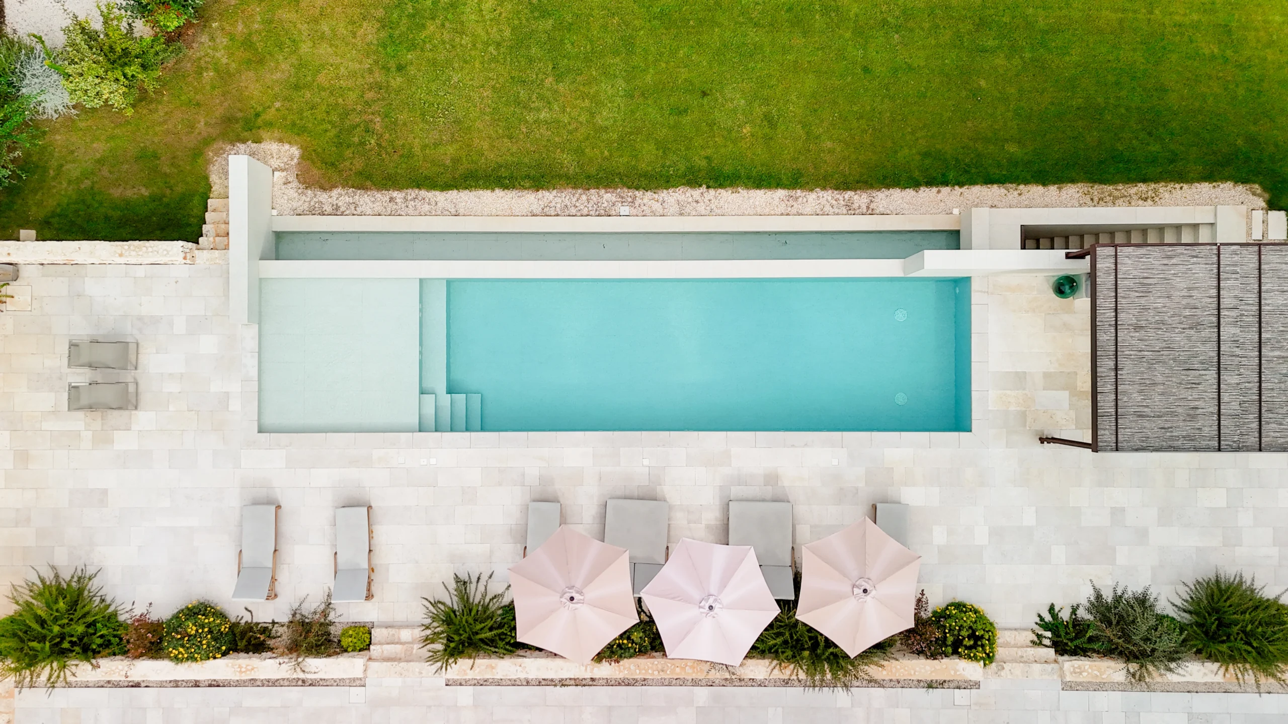 Aerial view of a luxury villa swimming pool with sun loungers and pergola in Puglia