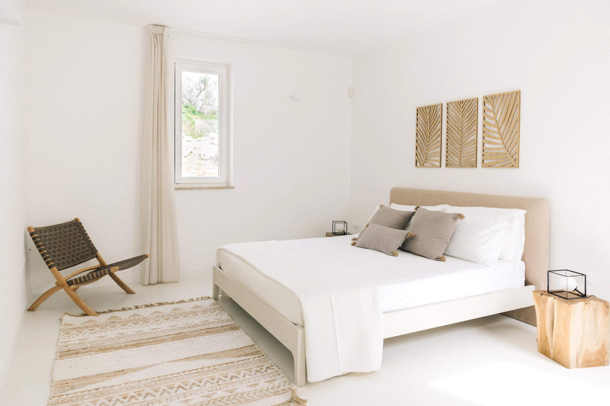 Spacious luxury bedroom with king-size bed, woven rug and artisan wooden nightstands