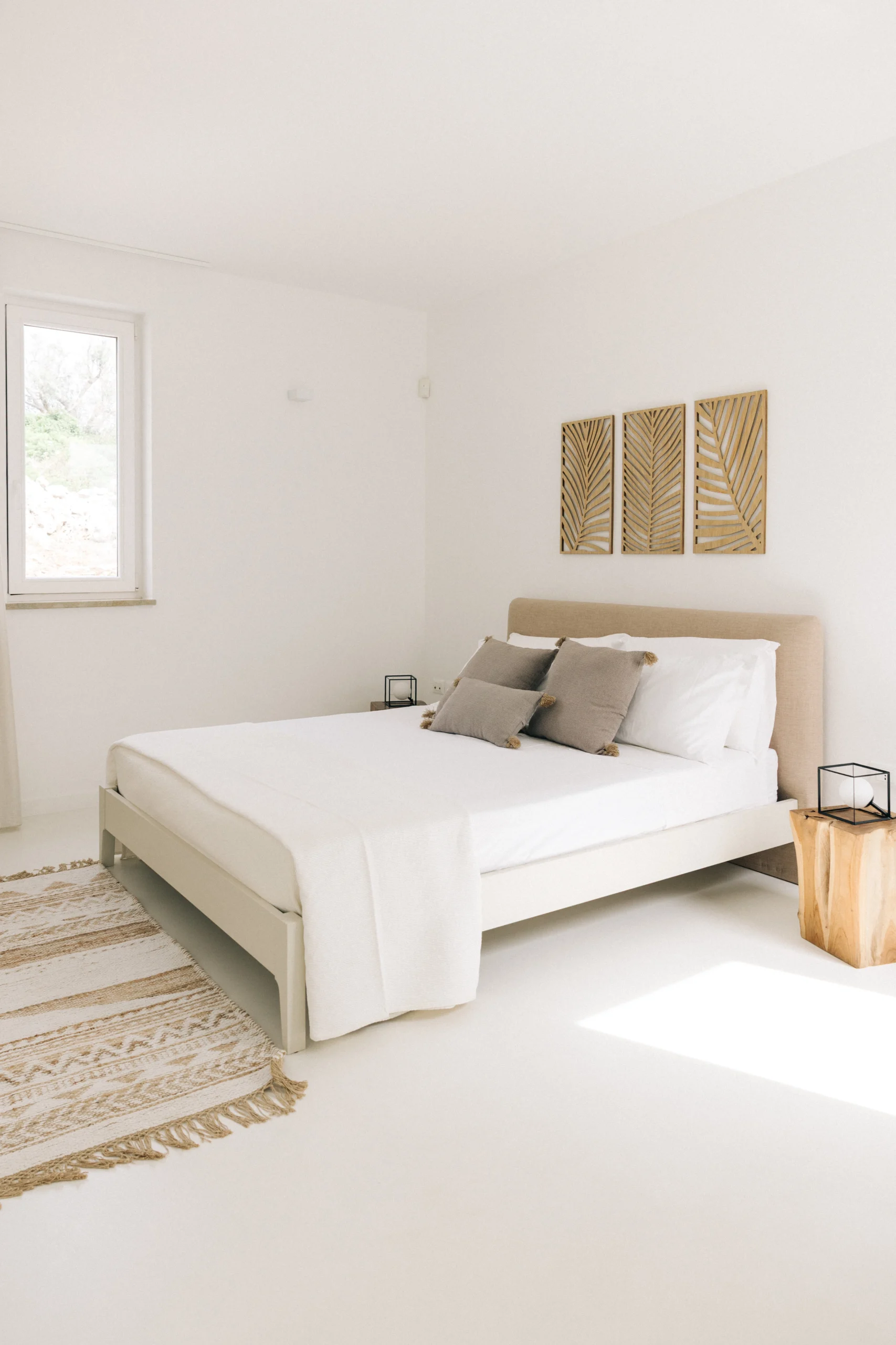 Bright white bedroom with contemporary Italian design and natural light from window