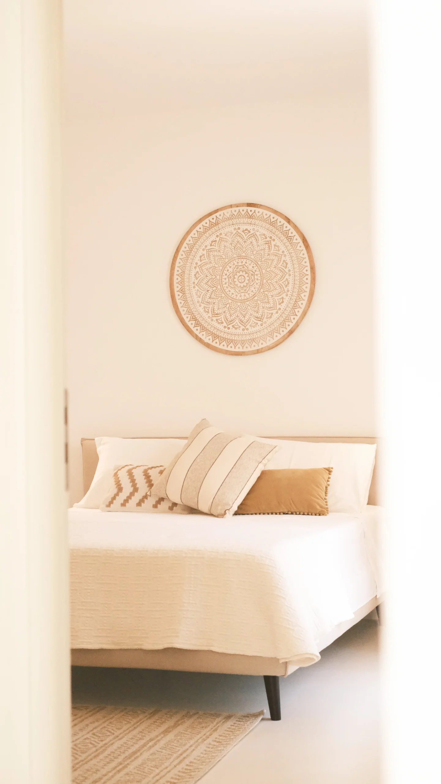 Elegant bedroom with circular wall art above bed in minimalist Mediterranean style